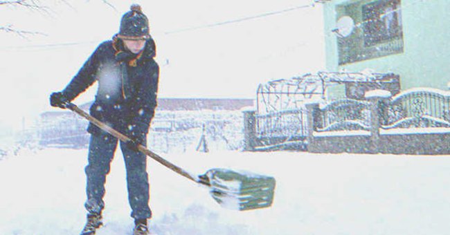 Boy cleaning the snow of a yard | Source: Shutterstock