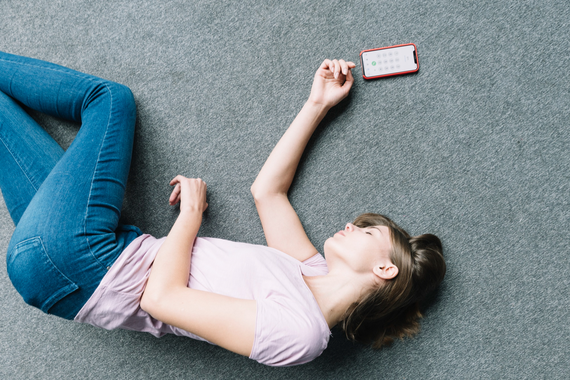 An unconscious woman laying next to a phone | Source: Freepik