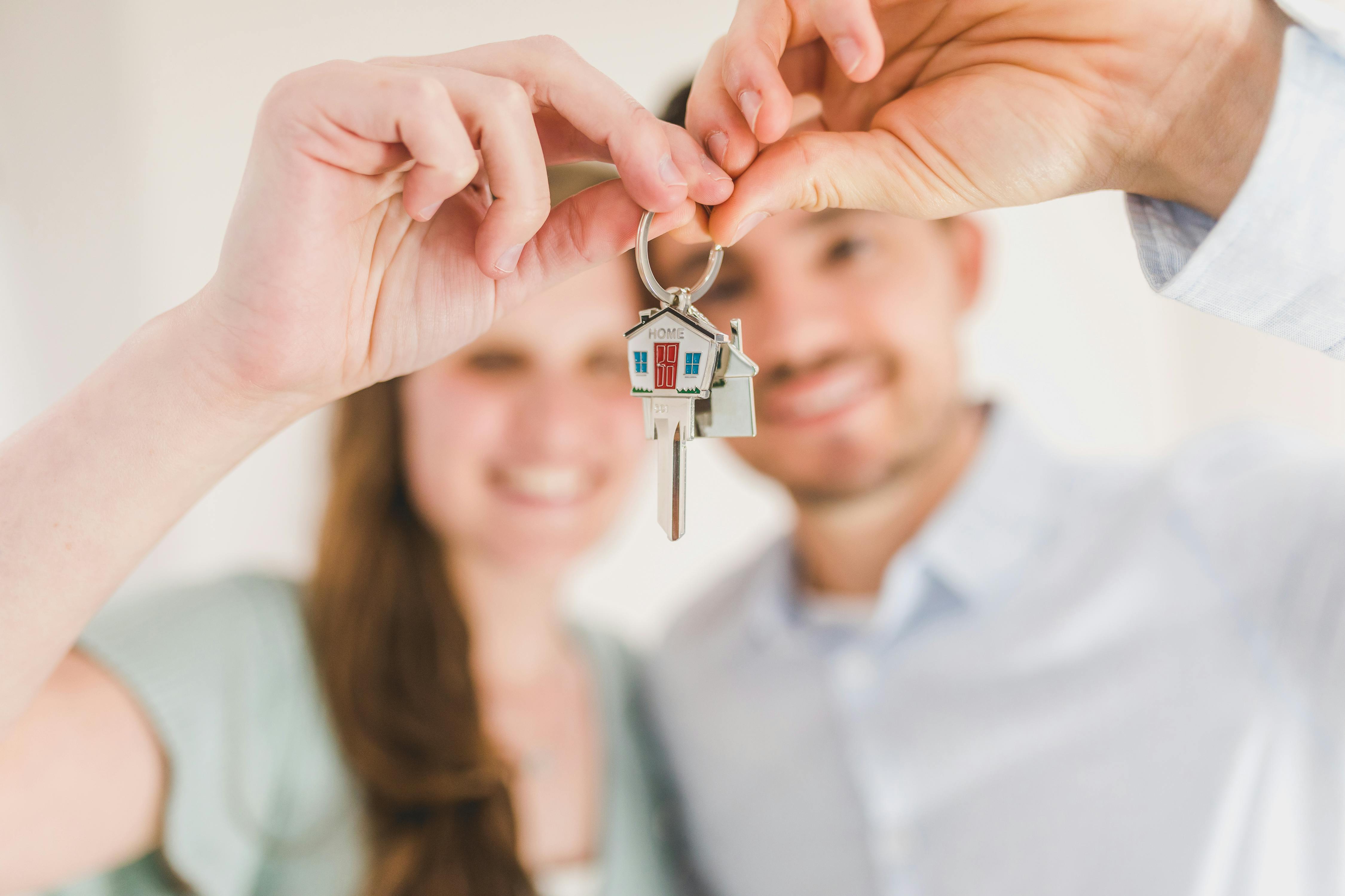 A young couple holding up a set of house keys | Source: RDNE Stock project on Pexels