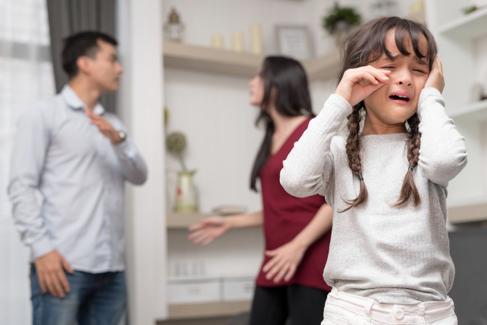 Niña llorando mientras sus padres tienen un conflicto matrimonial. | Foto: Shutterstock