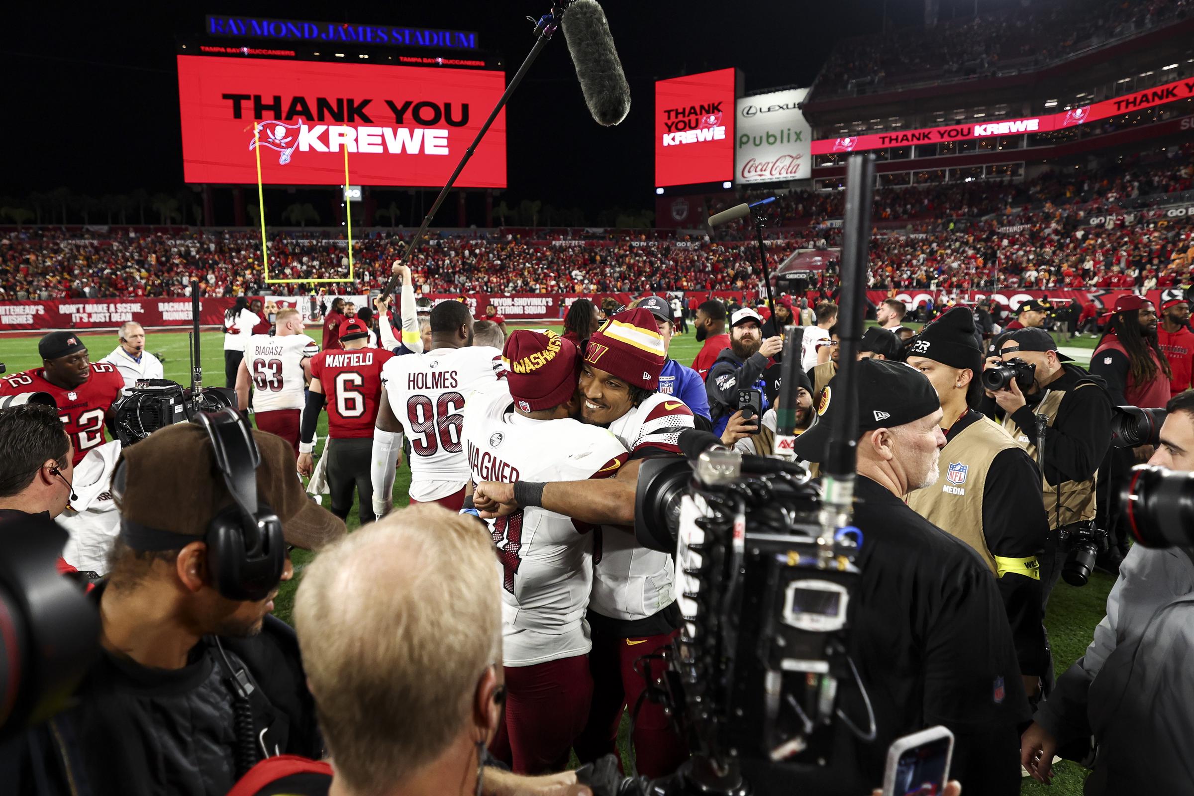 Jayden Daniels of the Washington Commanders hugs Bobby Wagner after an NFL football wild card playoff game against the Tampa Bay Buccaneers at Raymond James Stadium in Tampa, Florida, on January 12, 2025 | Source: Getty Images