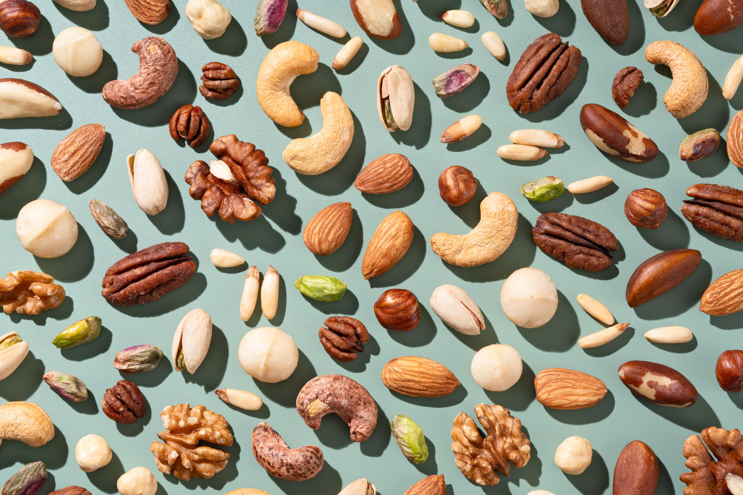 Various types of nuts arranged on a blue background | Source: Getty Images