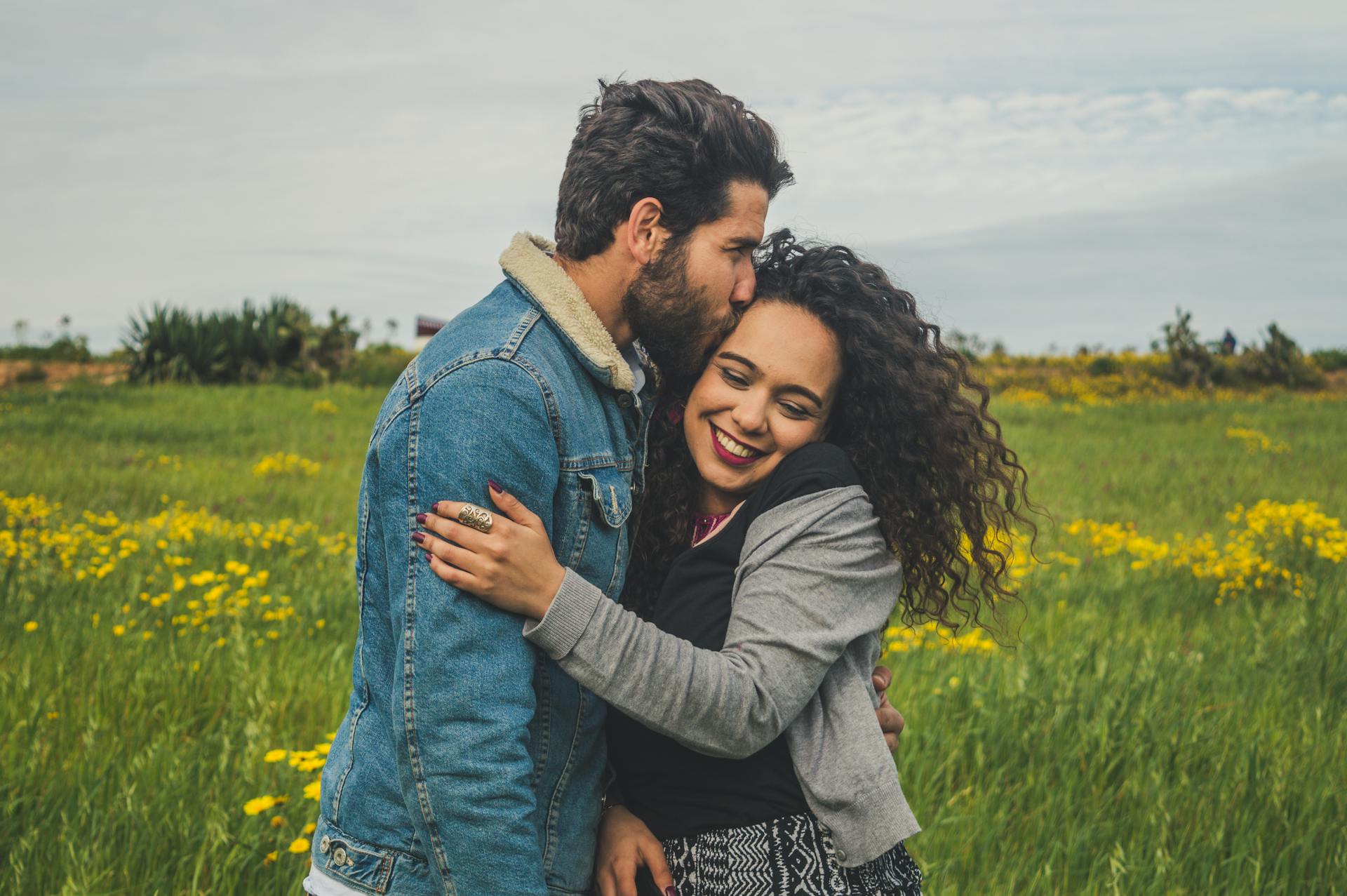 A young couple smiling in a field | Source: Pexels