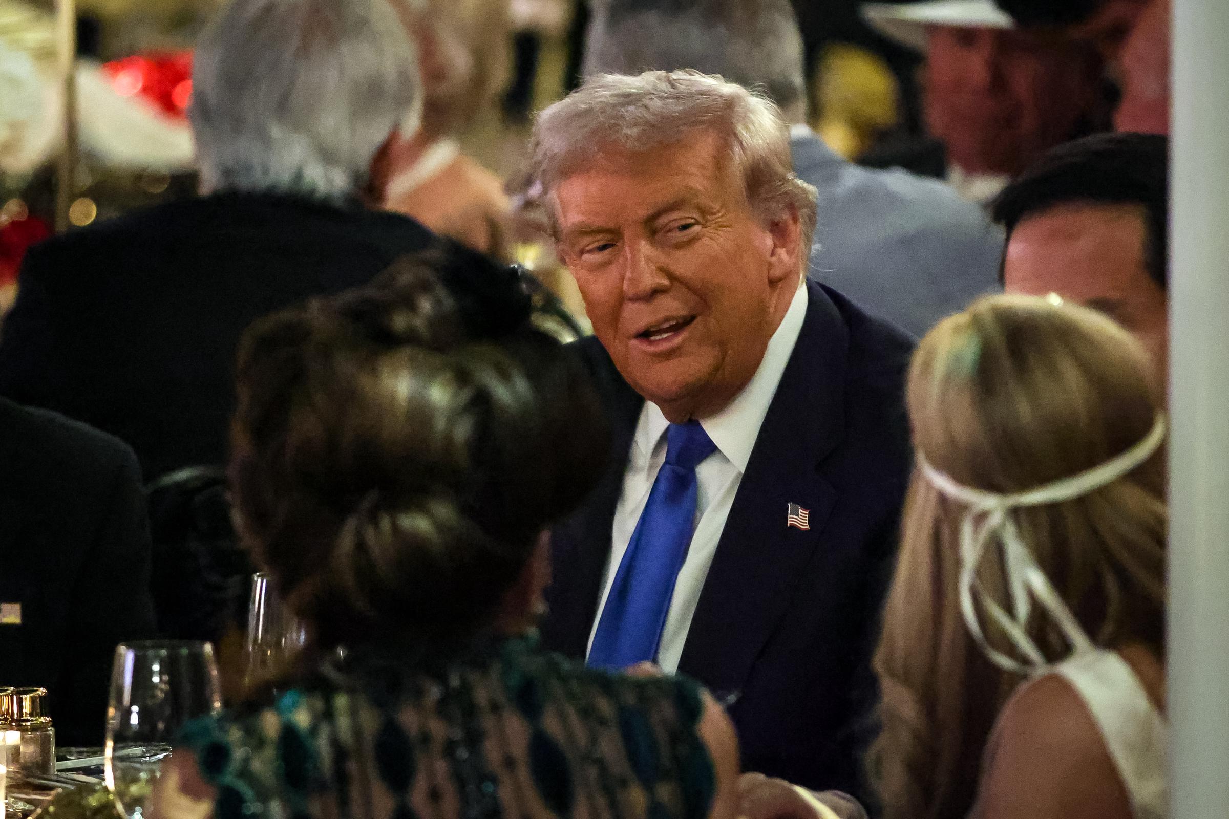 President Donald Trump talks with guests during a Halloween party at his Mar-a-Lago estate on October 31, 2025, at Palm Beach, Florida | Source: Getty Images