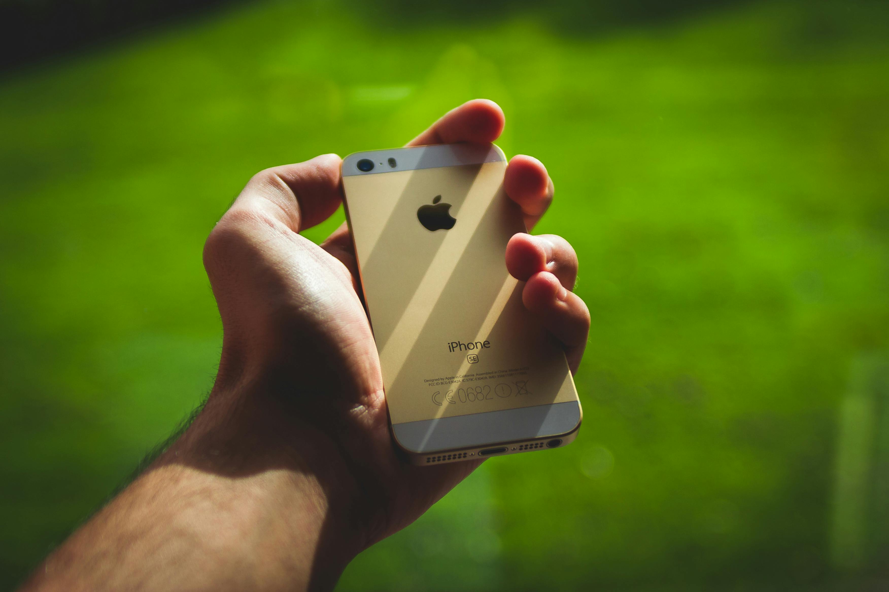 Man stretches out his hand with his phone | Source: Pexels