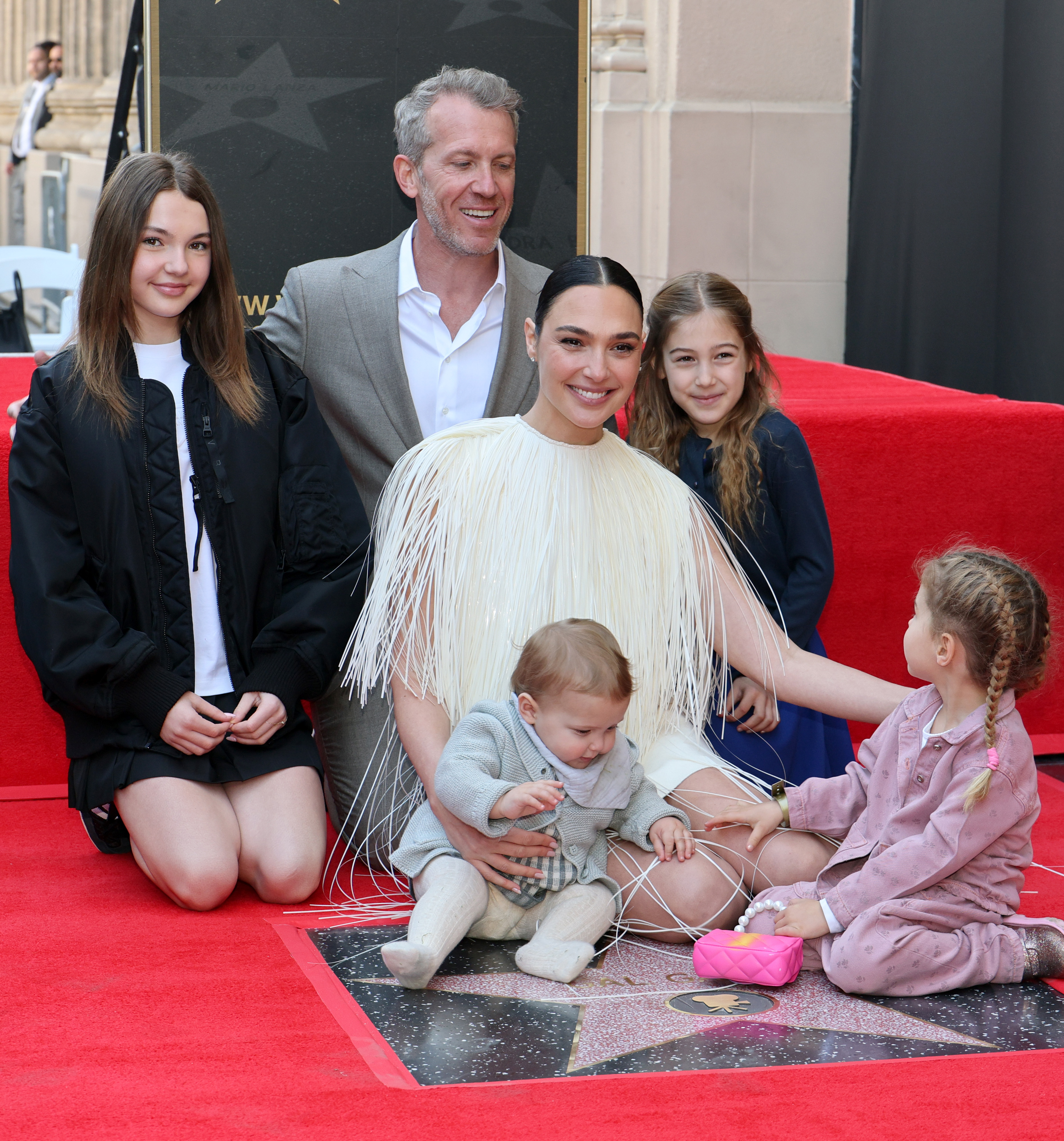 Gal Gadot smiles while being honored with a star on the Hollywood Walk of Fame as she poses alongside her husband Jaron Varsano and their four daughters, on March 18, 2025, in Hollywood, California | Source: Getty Images