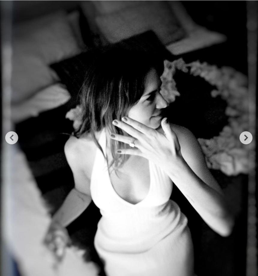 Stella Banderas in a sleeveless, low-cut white dress shows off her engagement ring, as seen in a post dated August 20, 2024 | Source: Instagram/melaniegriffith