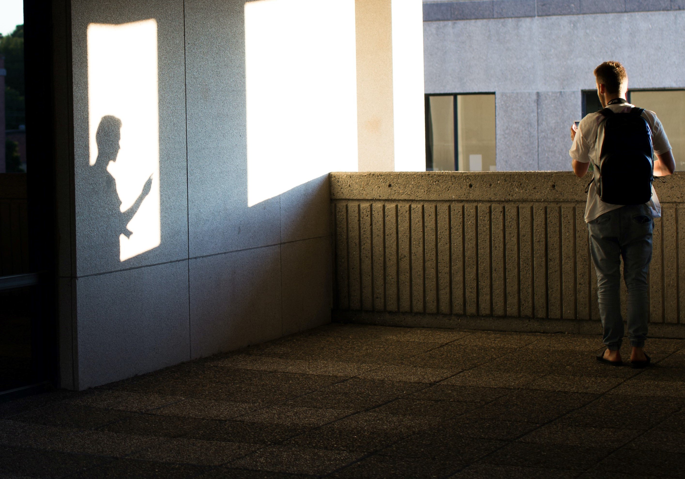 Un joven parado frente al balcón de un apartamento sin amoblar. | Foto: Unsplash