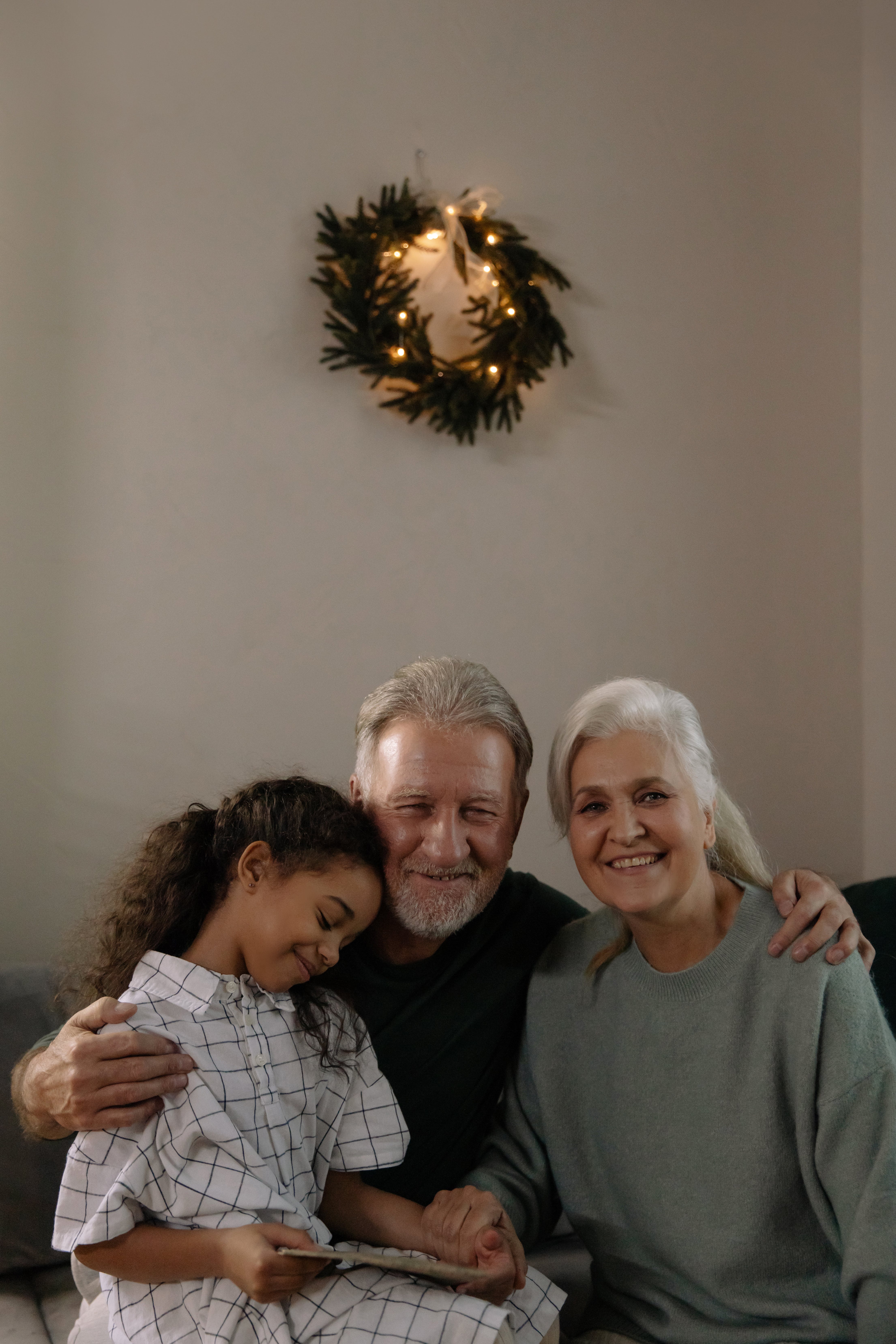 An elderly couple sitting with their granddaughter | Source: Pexels