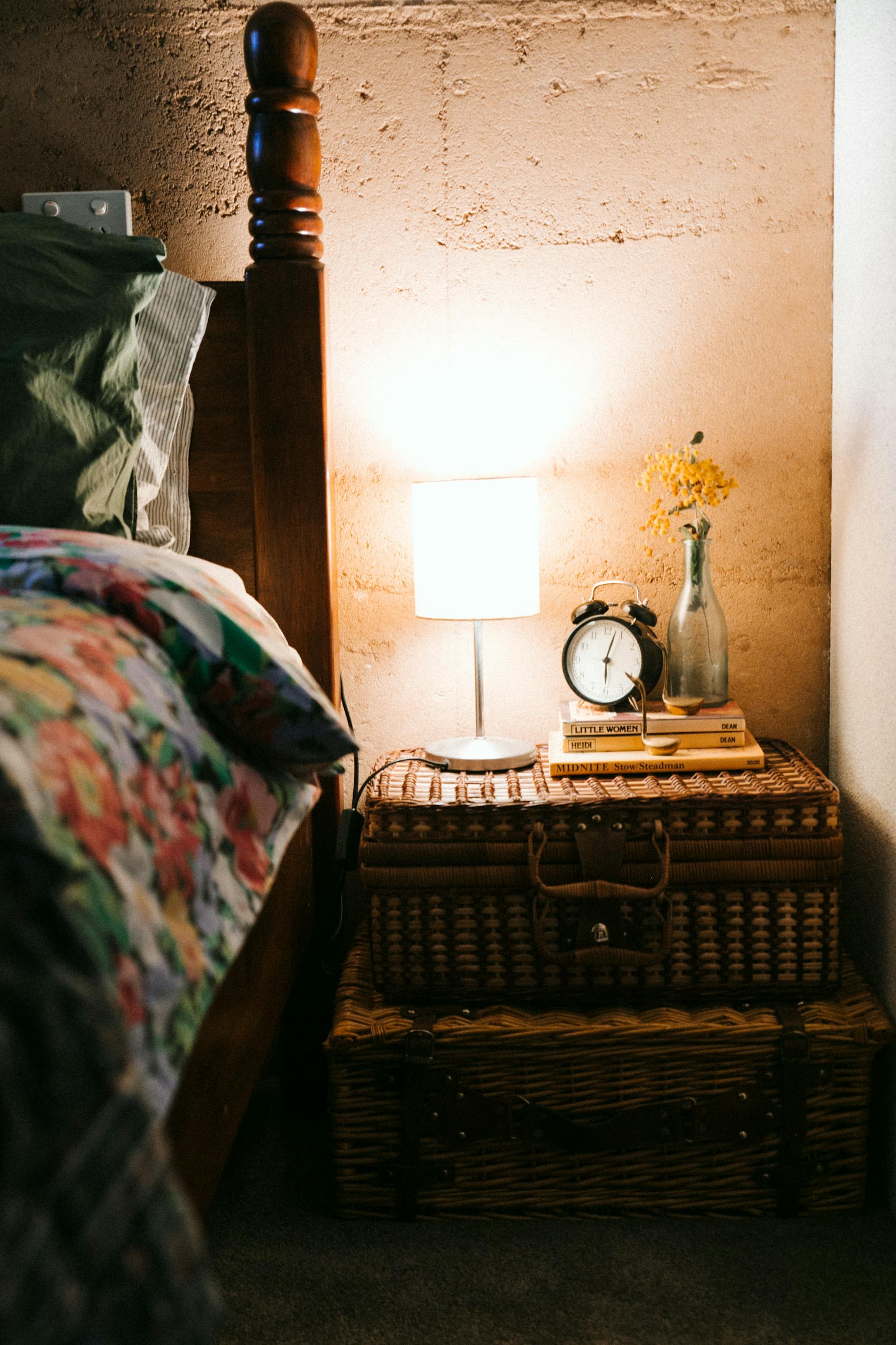 Bedroom with bedside lamp on | Source: Pexels