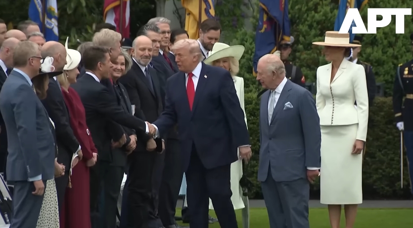 Donald Trump completes another handshake while moving further down the line, with King Charles III turning partially toward him and Queen Camilla visible behind, capturing the moment that drew widespread attention for its break in protocol. | Source: YouTube/APT