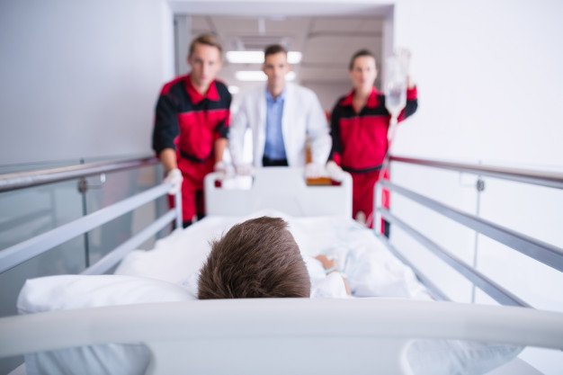 Doctores empujando una camilla. │Foto: Freepik