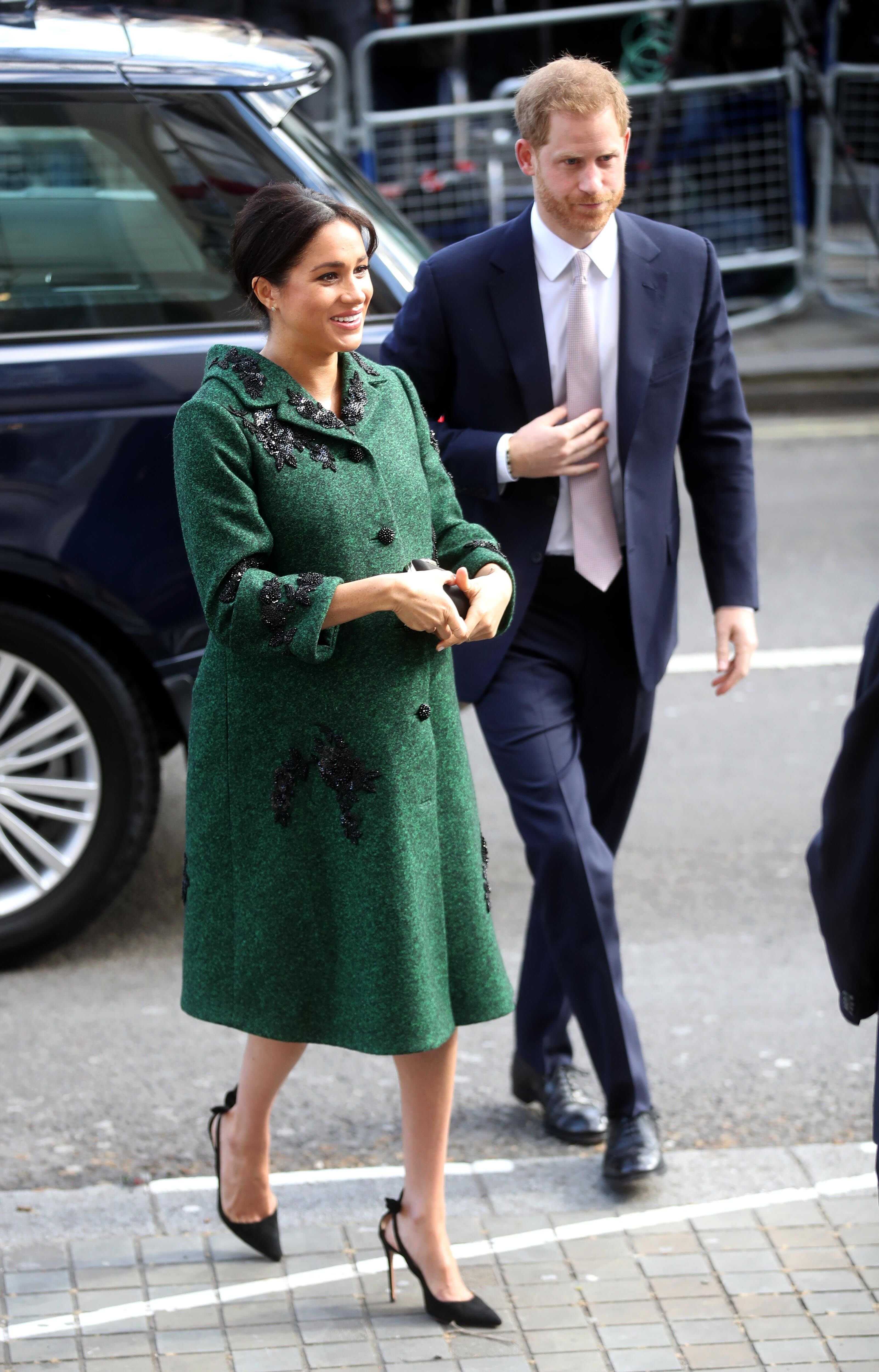 Meghan Markle walks with Prince Harry, in an emerald green coat. | Source: Getty Images