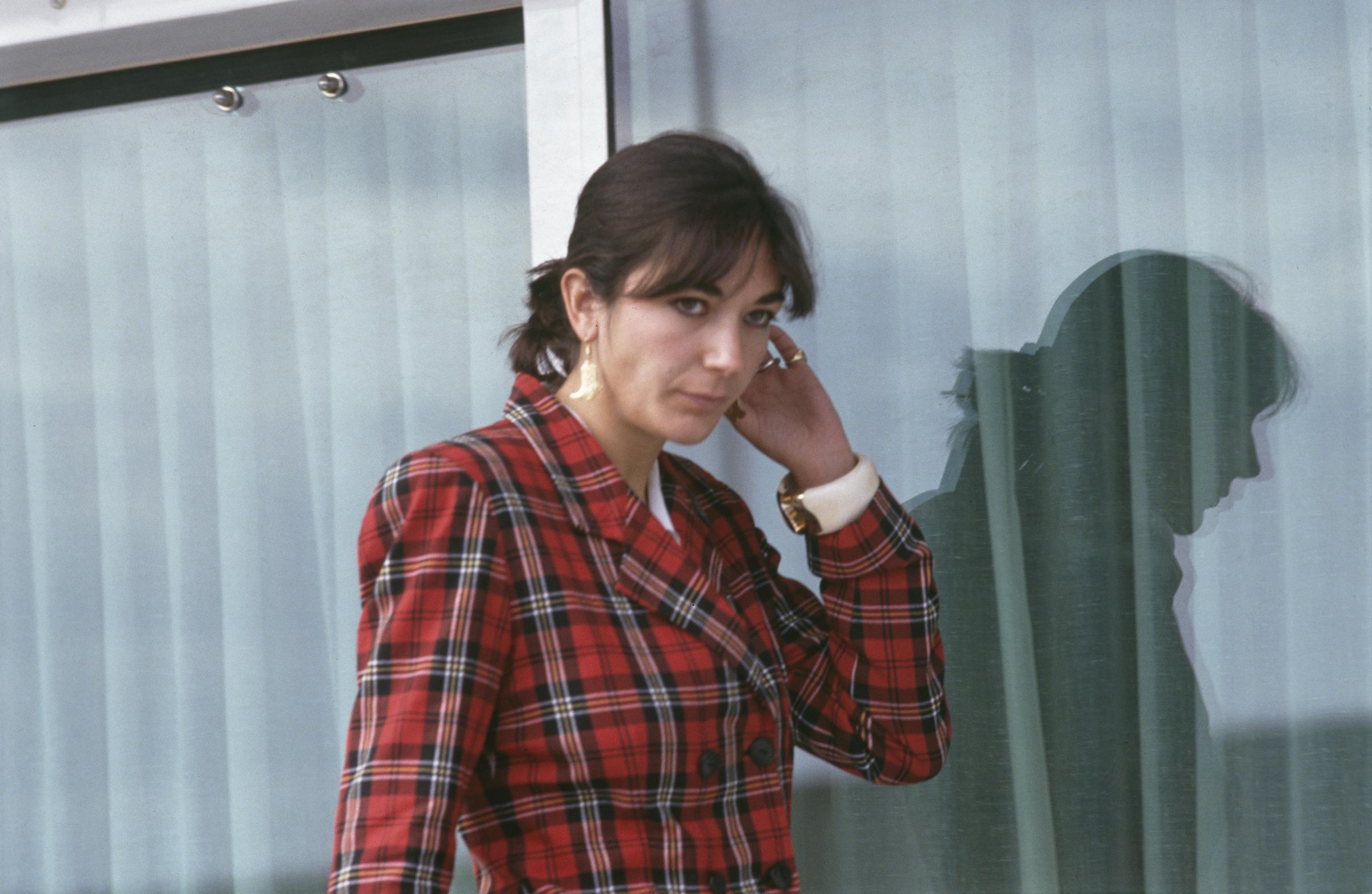 Calm Before the Scandal: Ghislaine Maxwell is seen aboard her father Robert Maxwell's yacht, "Lady Ghislaine", off Tenerife on 7 November 1991 — just days after the British tycoon's mysterious death at sea. Clad in a bold red tartan blazer and gold earrings, she glances toward the camera, her reflection hauntingly mirrored in the glass behind her. Years before her name would become forever linked to Jeffrey Epstein's sex trafficking empire, Maxwell cut a composed — even regal — figure.