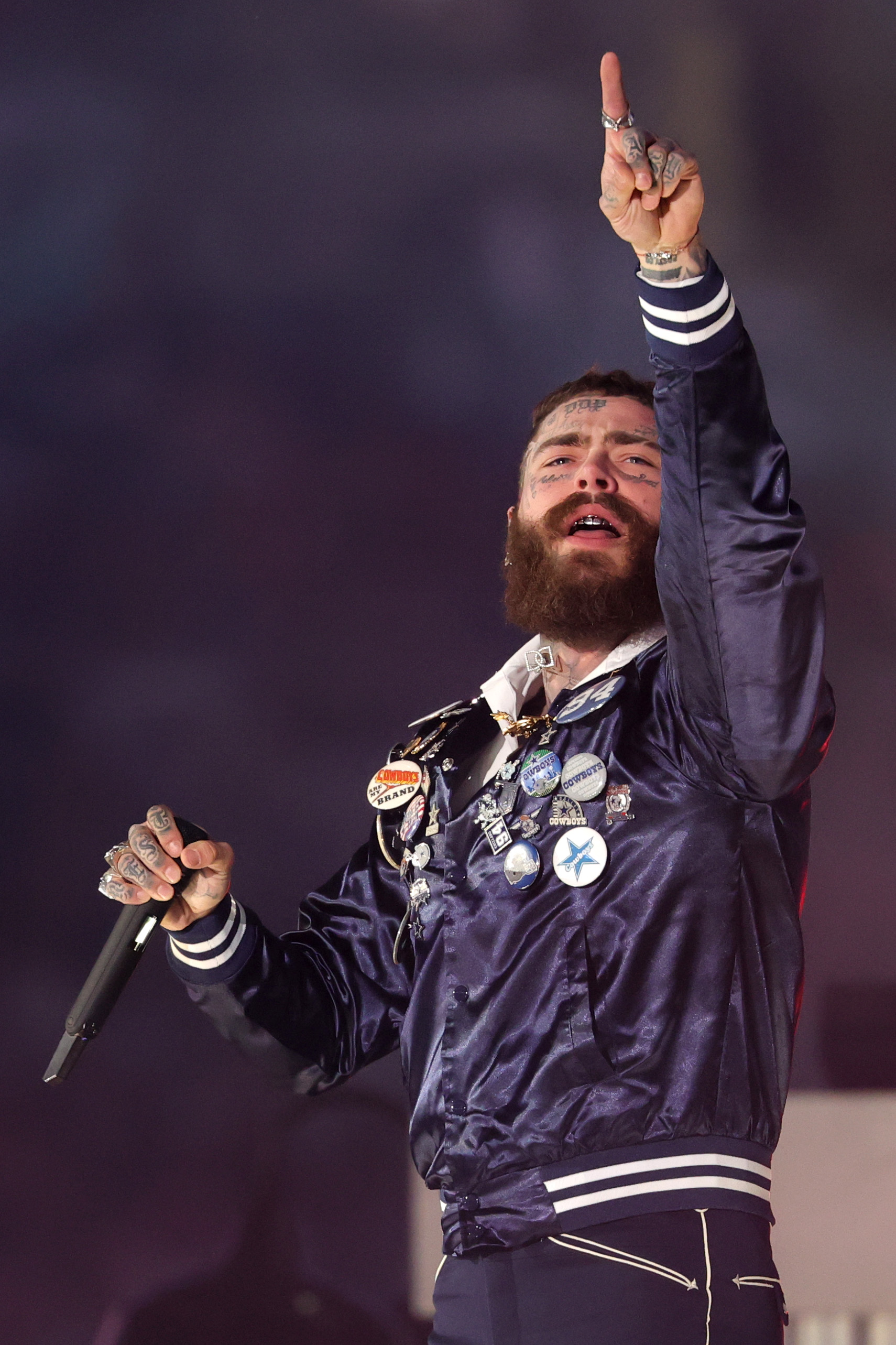 Post Malone raises his hand while performing solo during the Thanksgiving Day halftime show at AT&T Stadium on November 27, 2025 | Source: Getty Images