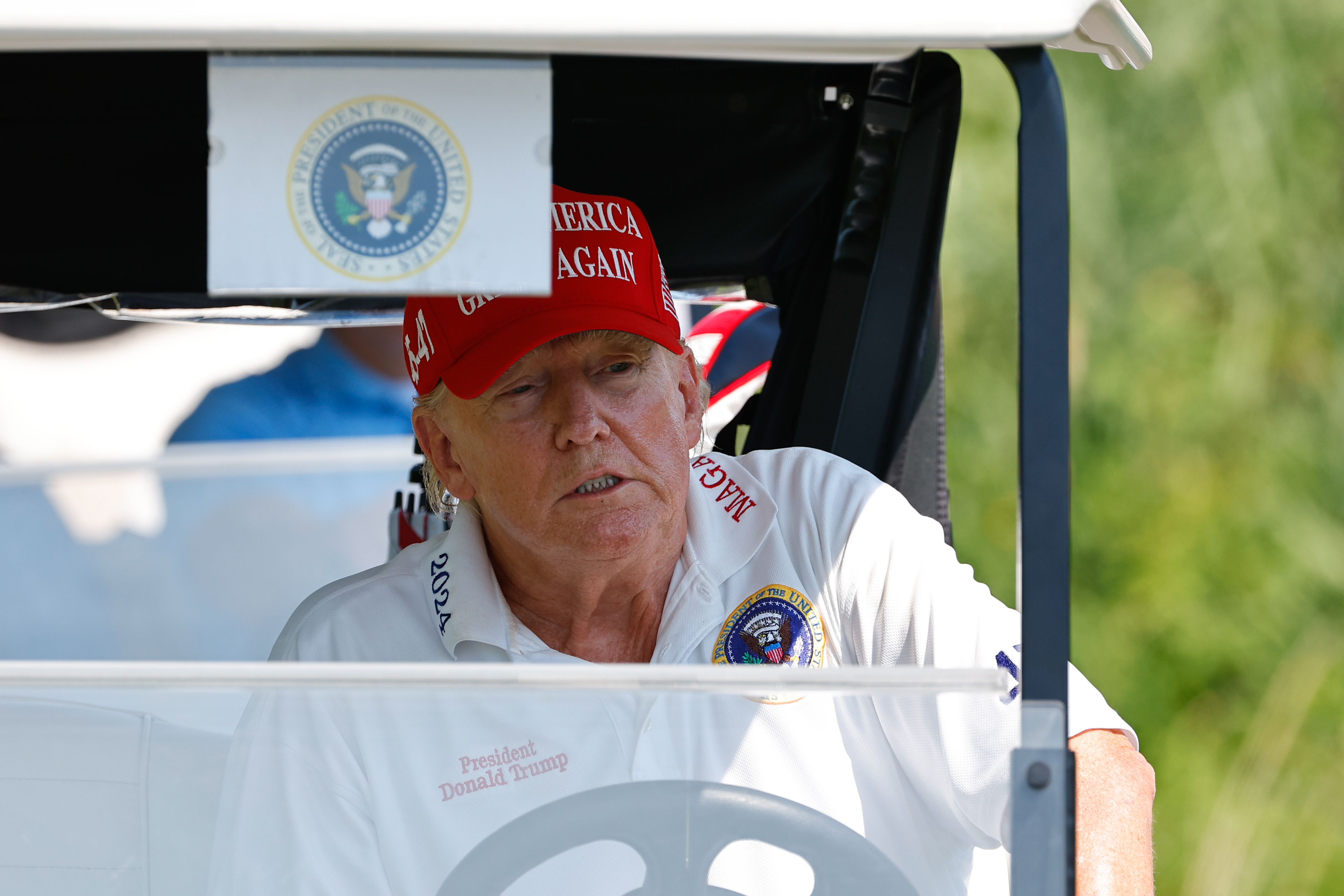 President Donald Trump is seen driving a golf cart from the 15th tee during the practice round at Trump National Golf Club on August 9, 2023, in Bedminster, New Jersey | Source: Getty Images