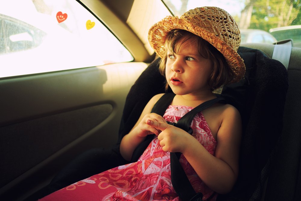 Girl sitting in car seat. | Photo: Shutterstock