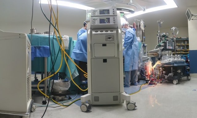Une machine d'assistance respiratoire et des médecins qui opèrent un patient | Photo : Unsplash