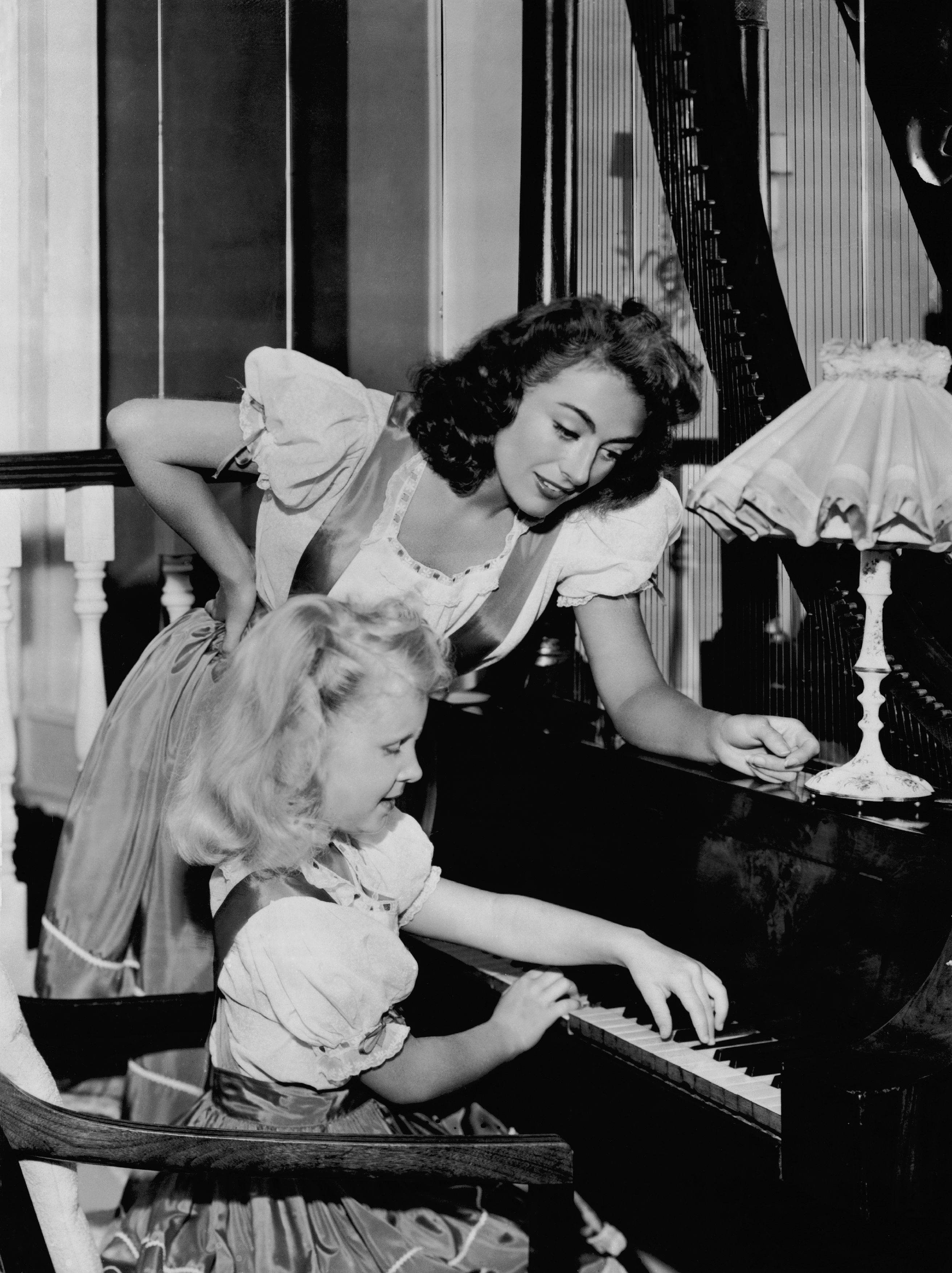 Dancer Joan Crawford with her daughter Christina during her piano lesson on July 25, 1947. / Source: Getty Images