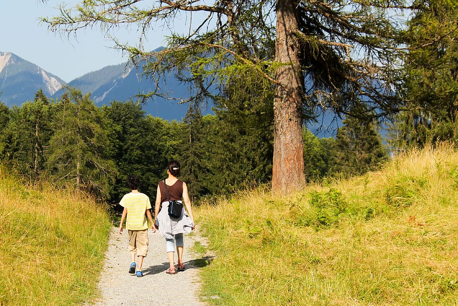 Mujer sin caminando con su hijo tomados de la mano por un sendero. | Foto: PxFuel Mujer sin caminando con su hijo tomados de la mano por un sendero. | Foto: PxFuel