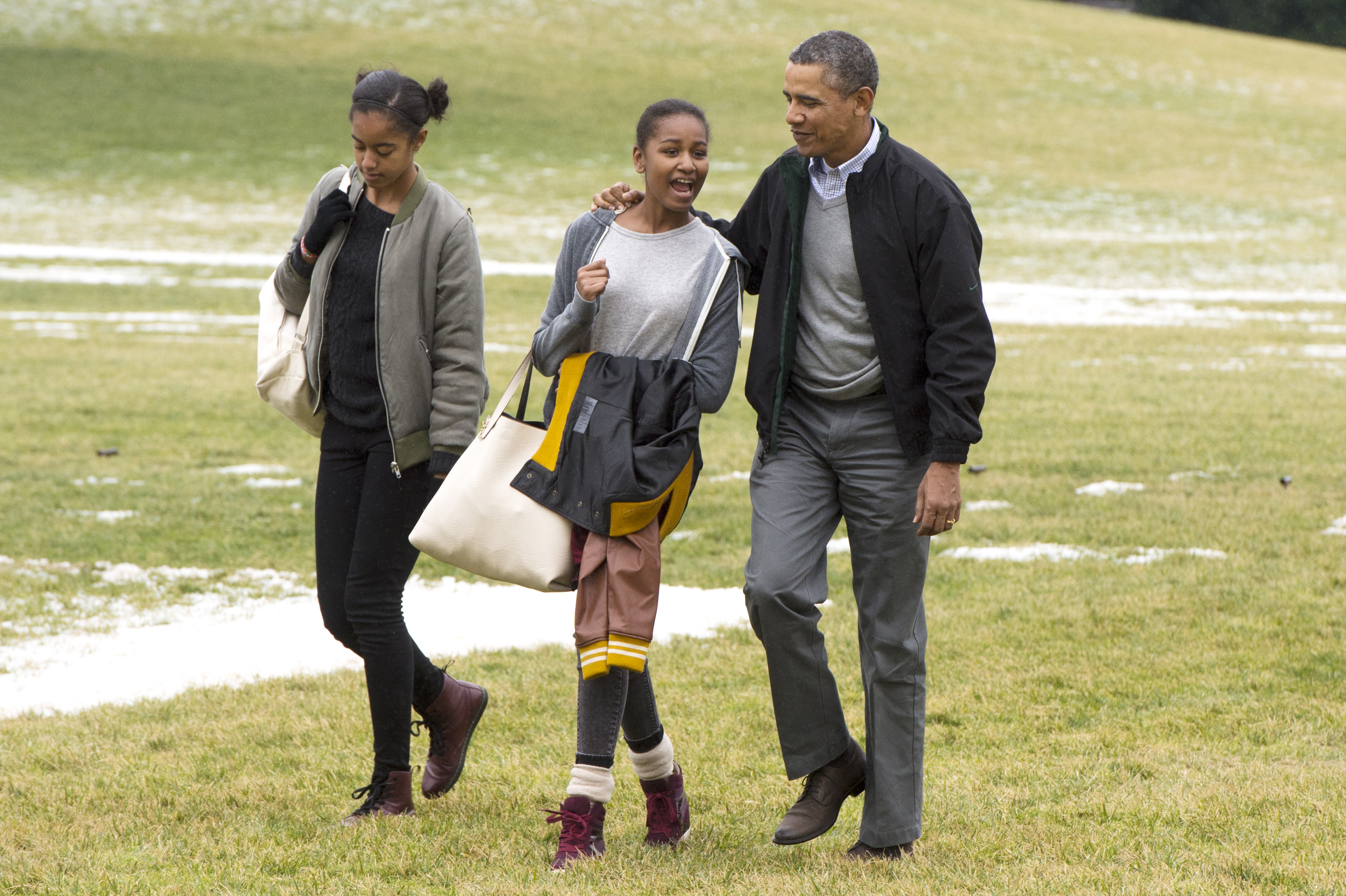 Malia, Sasha, and Barack Obama walking across the South Lawn of the White House after arriving by Marine One in Washington, D.C. on January 5, 2014. | Source: Getty Images