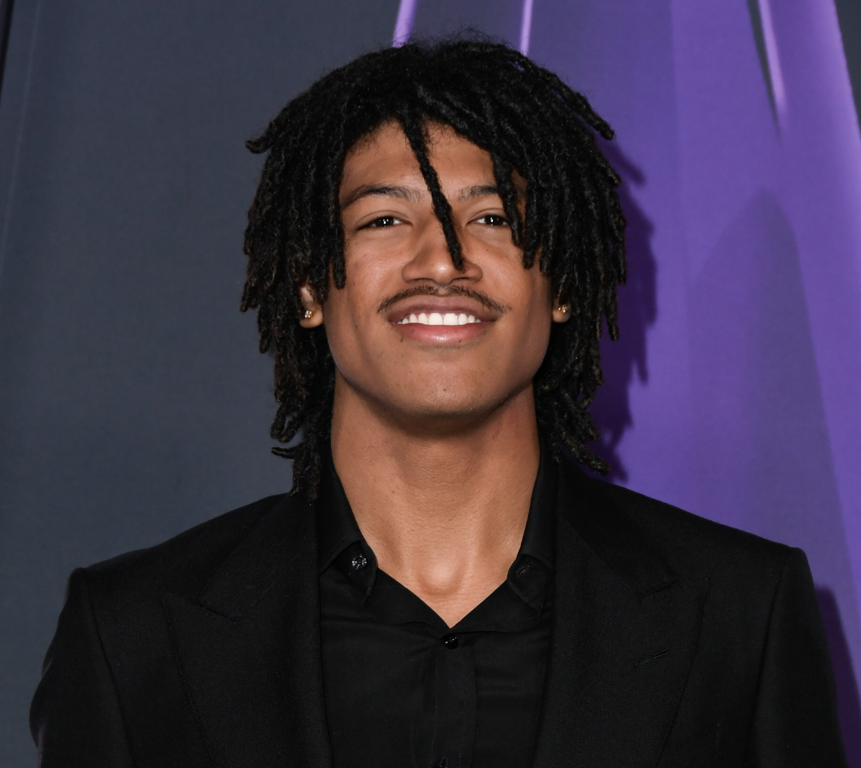 Henry Samuel showed a confident presence at the 2025 AMAs, wearing his locs in a natural, shoulder-length style. His neatly groomed mustache and radiant smile highlighted his youthful features and sharp bone structure.
