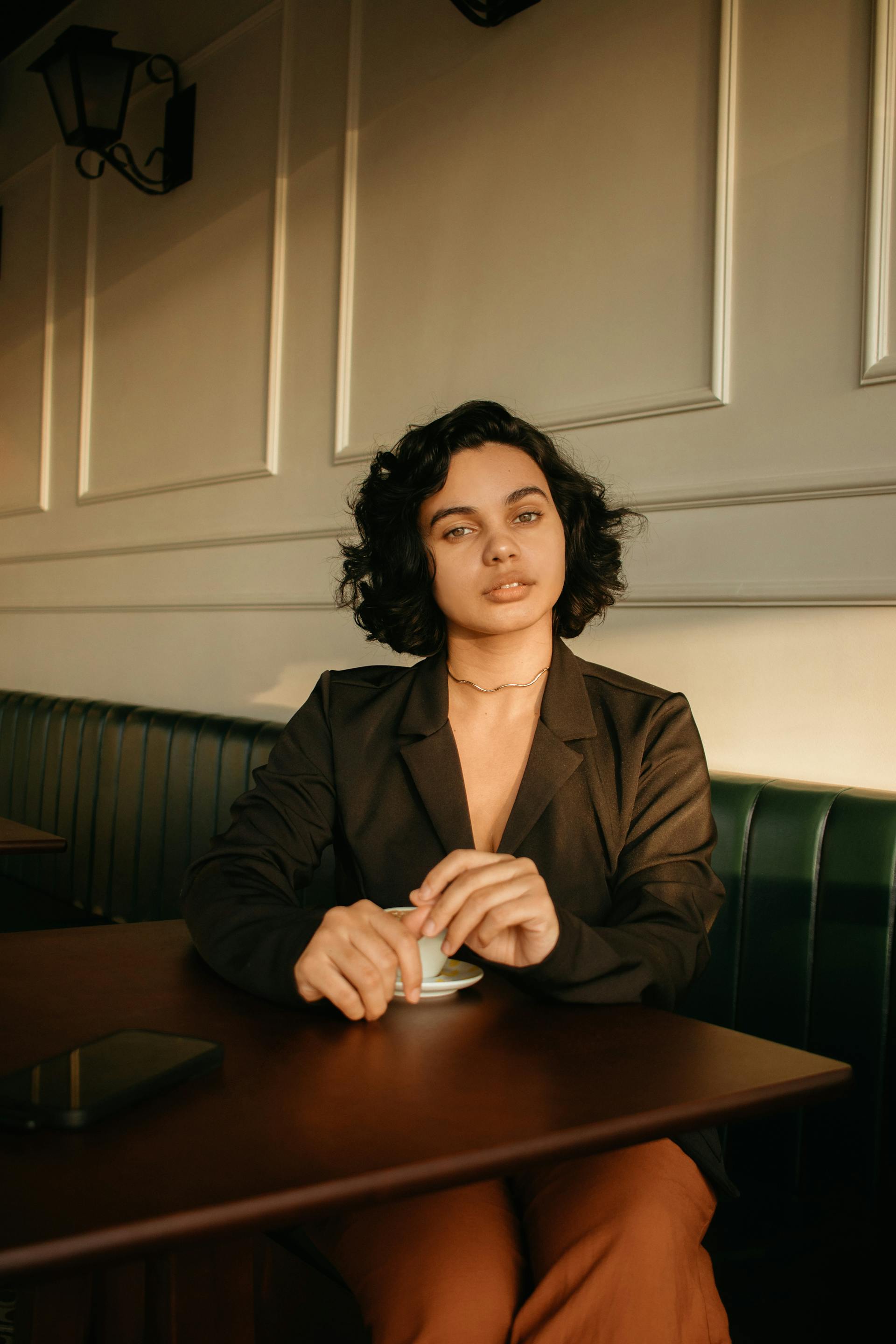 A woman drinking coffee in a cafe | Source: Pexels