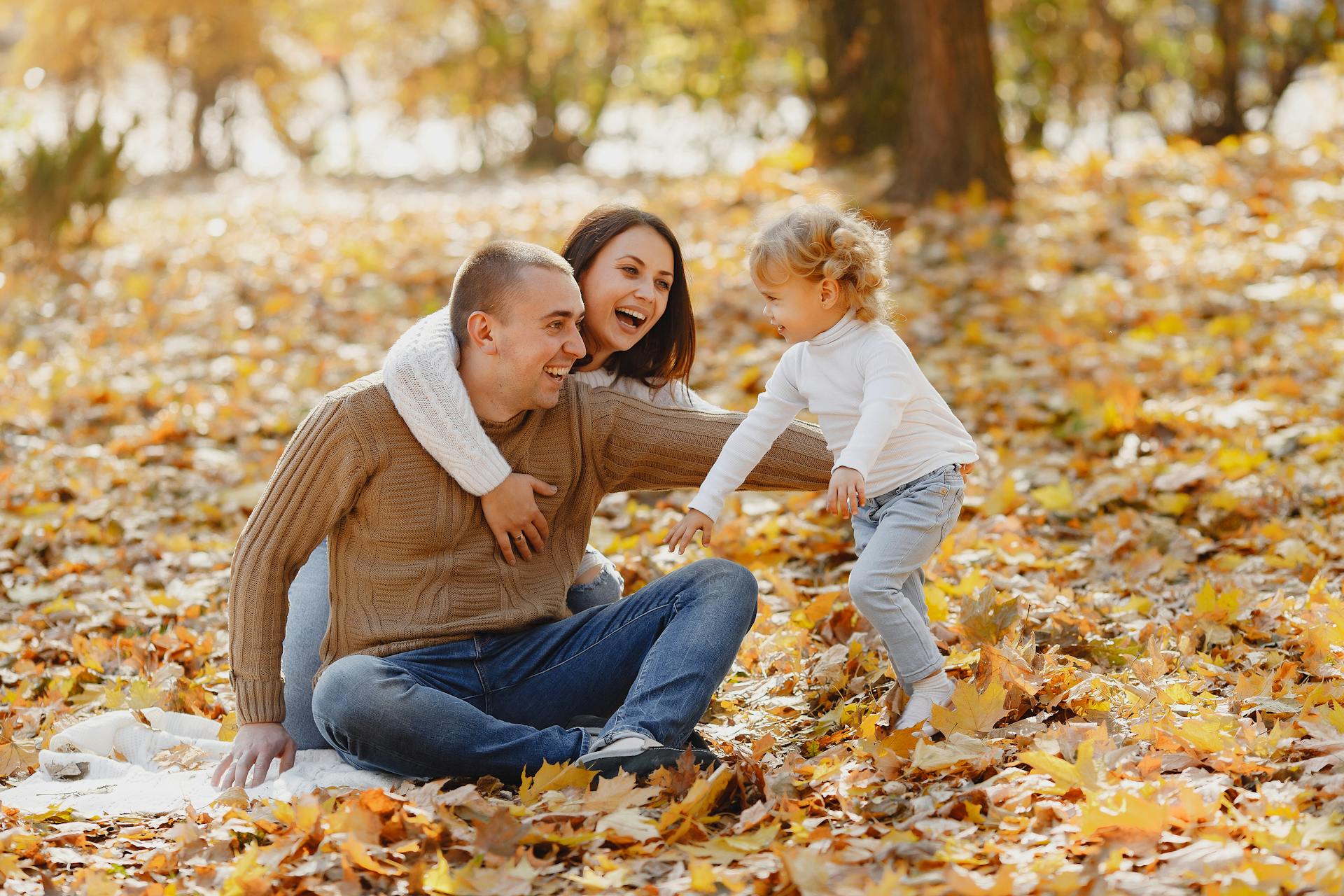 A couple having fun in the park with their little daughter | Source: Pexels