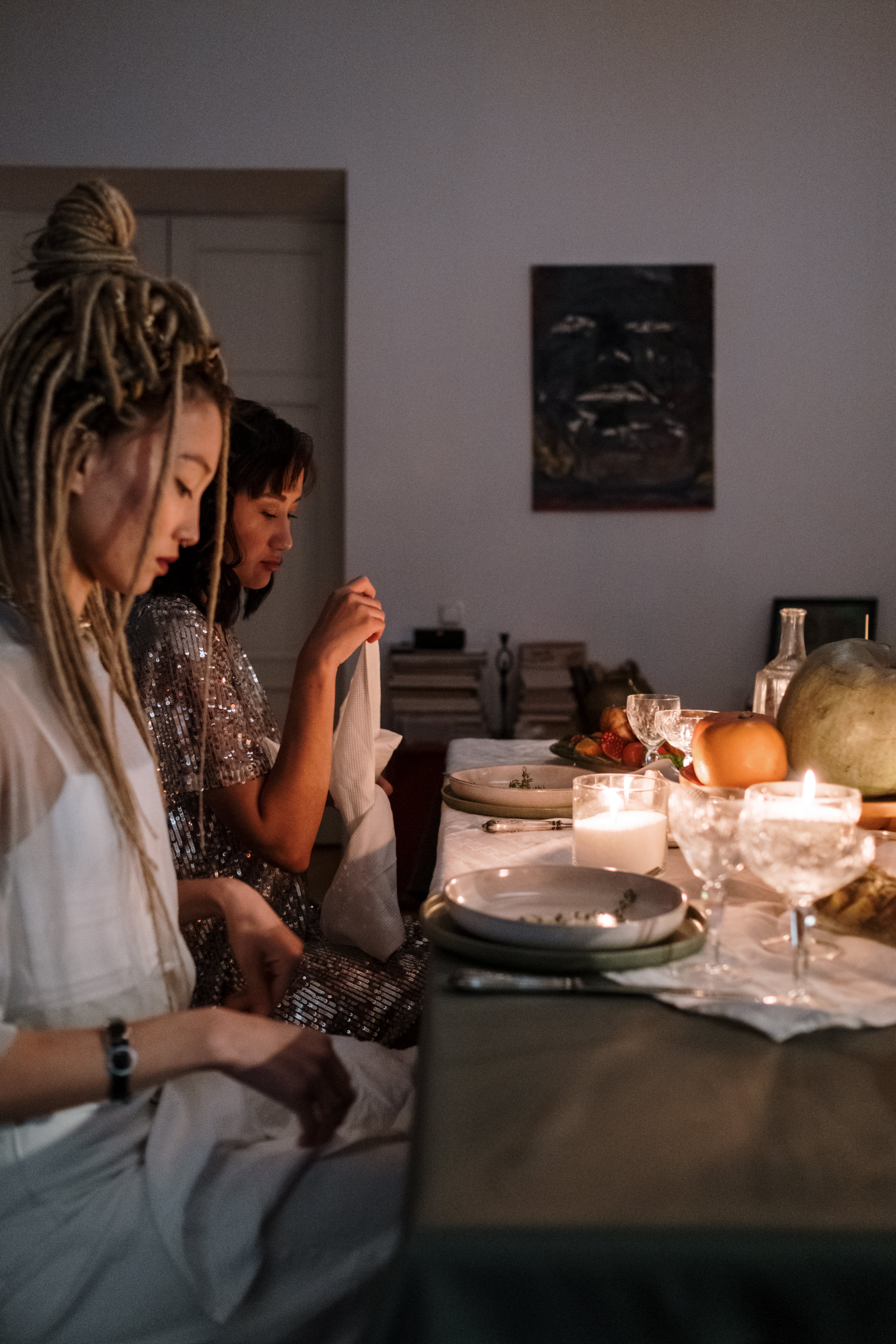 Two women looking down while sitting at a dinner table | Source: Pexels