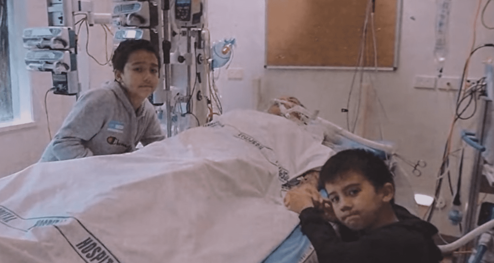 Dianne Akurangi in coma with her two sons by her bedside.| Source: youtube.com/gisborneherald 