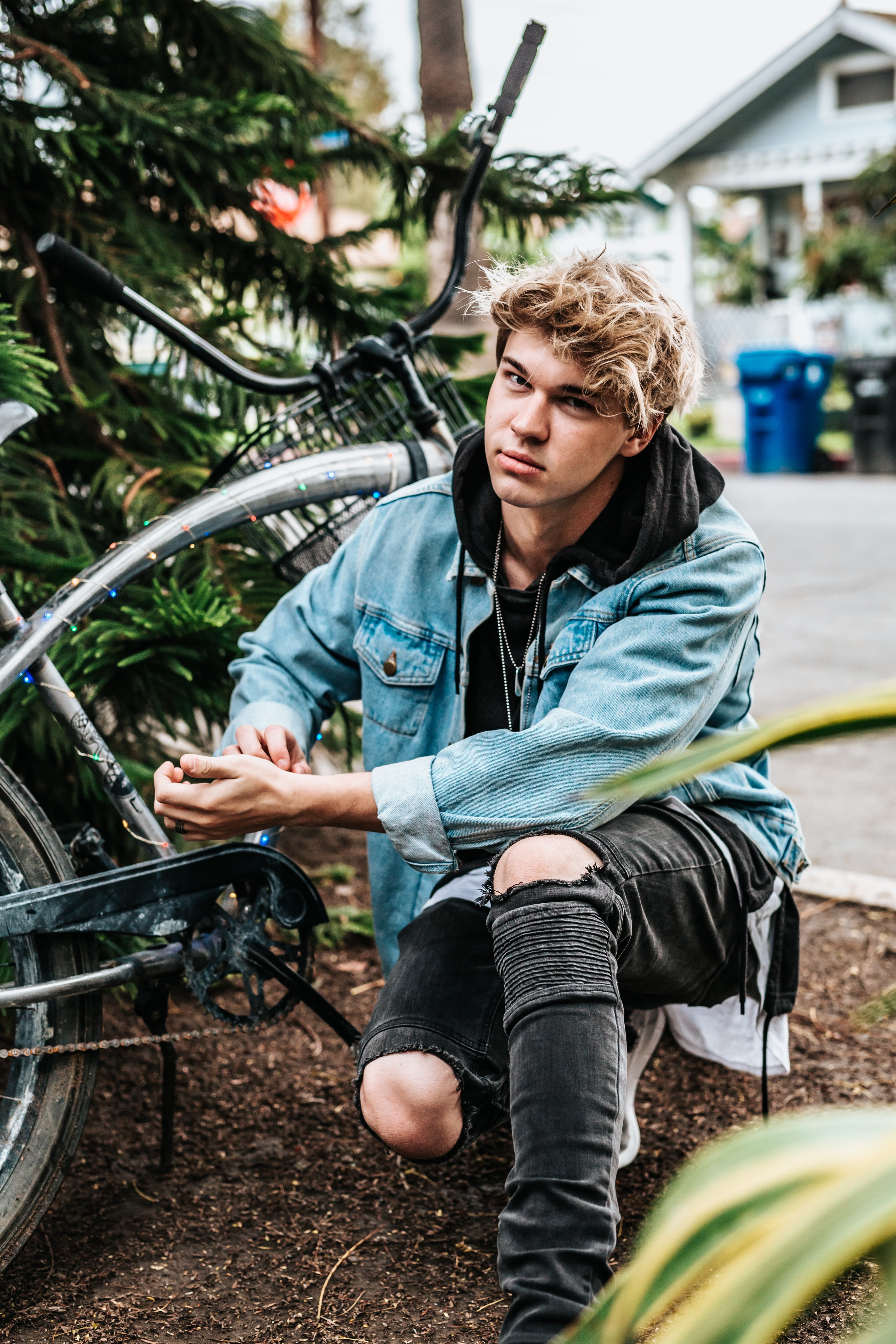 Teenage boy crouched near a bike | Source: Unsplash /  Tyler Nix