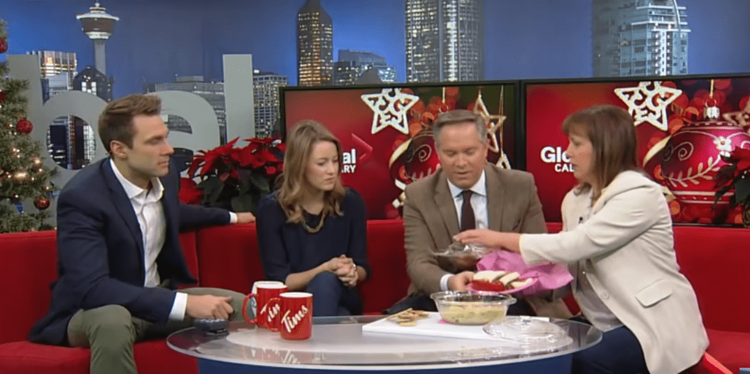 Global News Calgary anchor Leslie Horton sharing her favorite treat with co-anchors Scott Fee, Jordan Witzel and Amber Schinkel. | Photo: YouTube/Global News