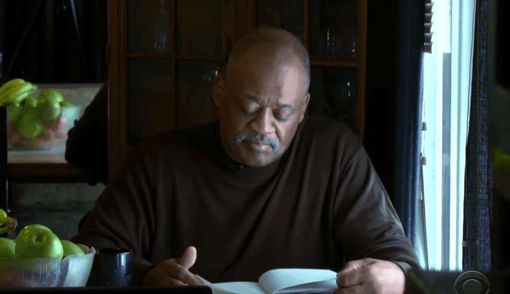 Lamont Thomas reading book at home. | Photo: YouTube/CBS Evening News
