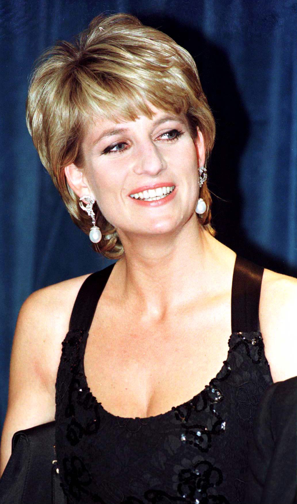 The English princess, who was 35 in 1996, attended a humanitarian awards ceremony in New York with an elegance that felt both modern and timeless. Her short, feathered hair, radiant smile, and classic black evening gown with subtle sequins captured a regal poise that blended glamour with unmistakable warmth. She carried herself like royalty — not just in title, but in presence.