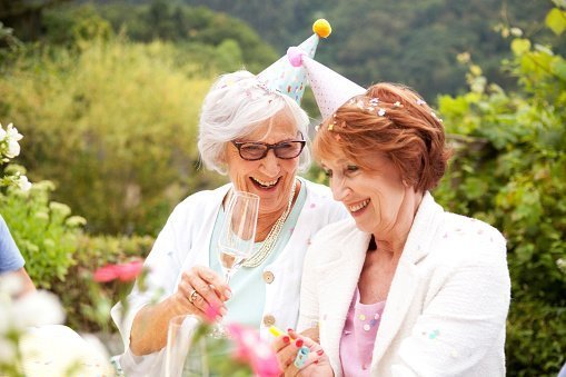 Two elderly woman pictured drinking champagne at birthday party | Photo: Getty Images