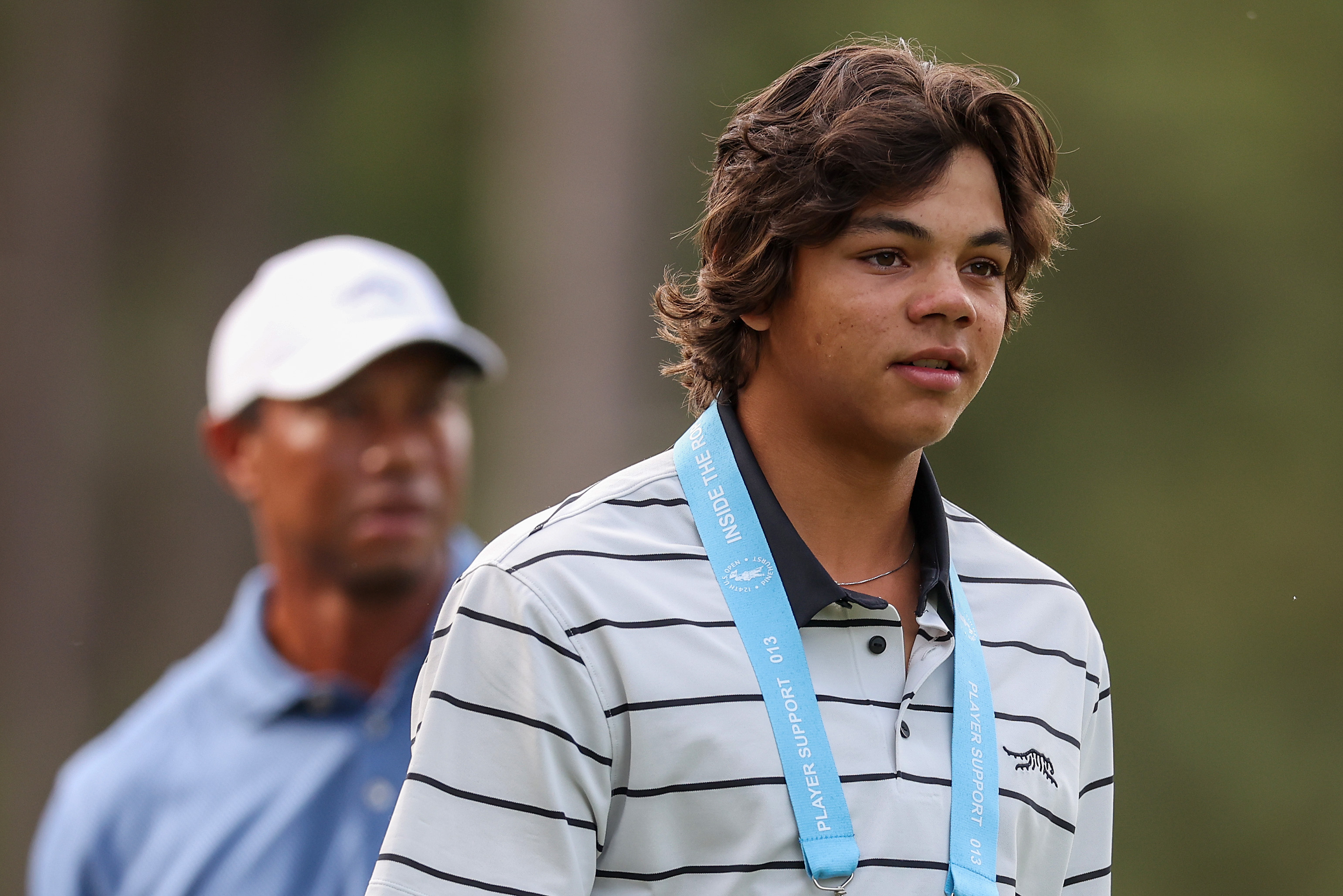 Charlie Woods look serious in front of his father Tiger Woods during a practice round prior to the U.S. Open at Pinehurst Resort in North Carolina on June 10, 2024. | Source: Getty Images