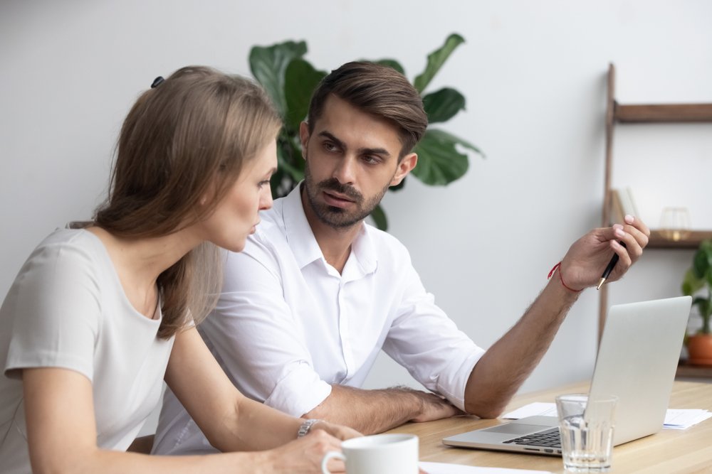 Compañeros de trabajo sentados en el escritorio de la oficina mientras discuten proyectos e intercambian diferentes opiniones. | Fuente: Shutterstock