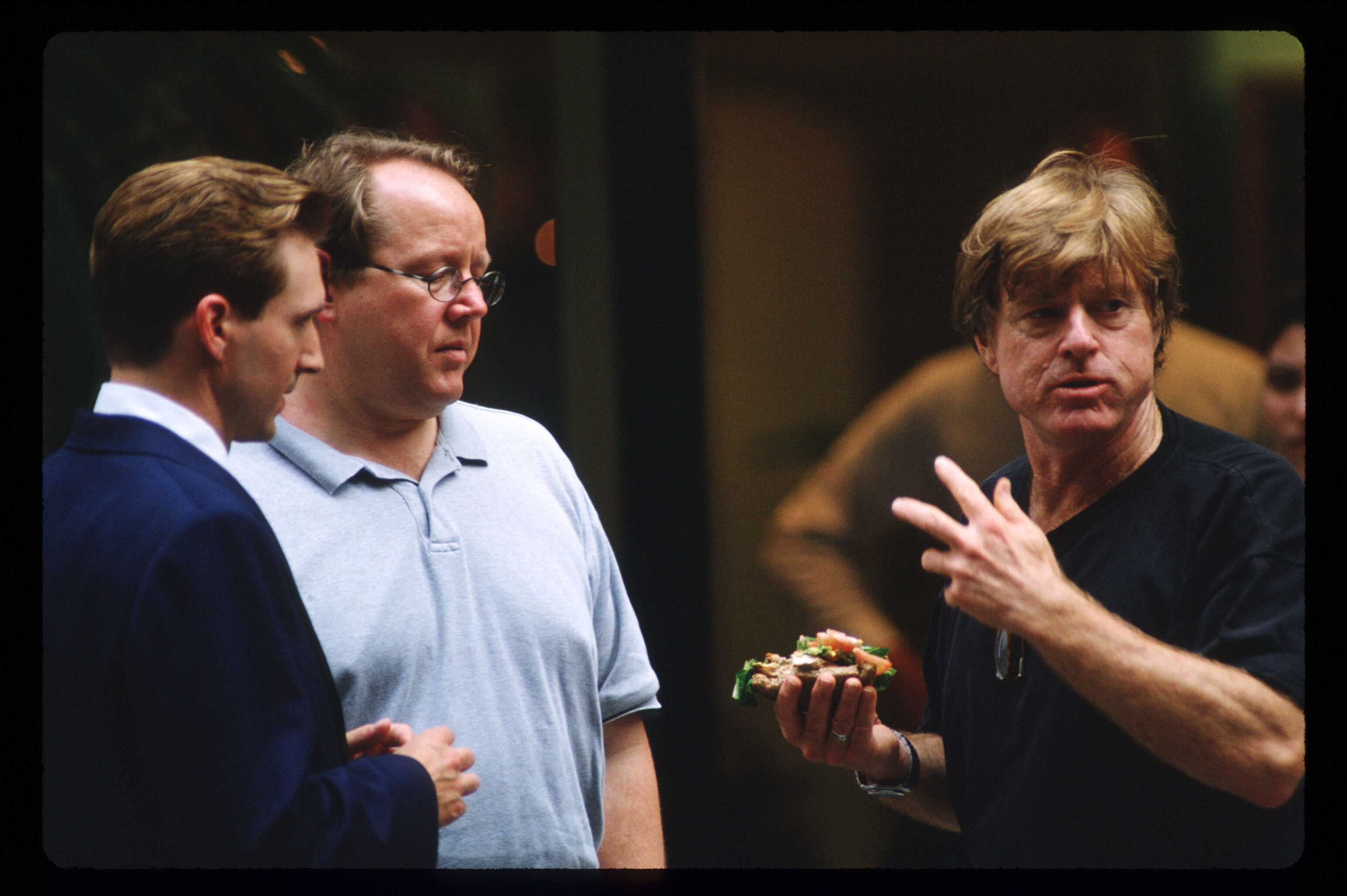 Robert Redford speaks with Ralph Fiennes while directing a scene from his new film "Quiz Show" on June 19, 1993, in New York City | Source: Getty Images