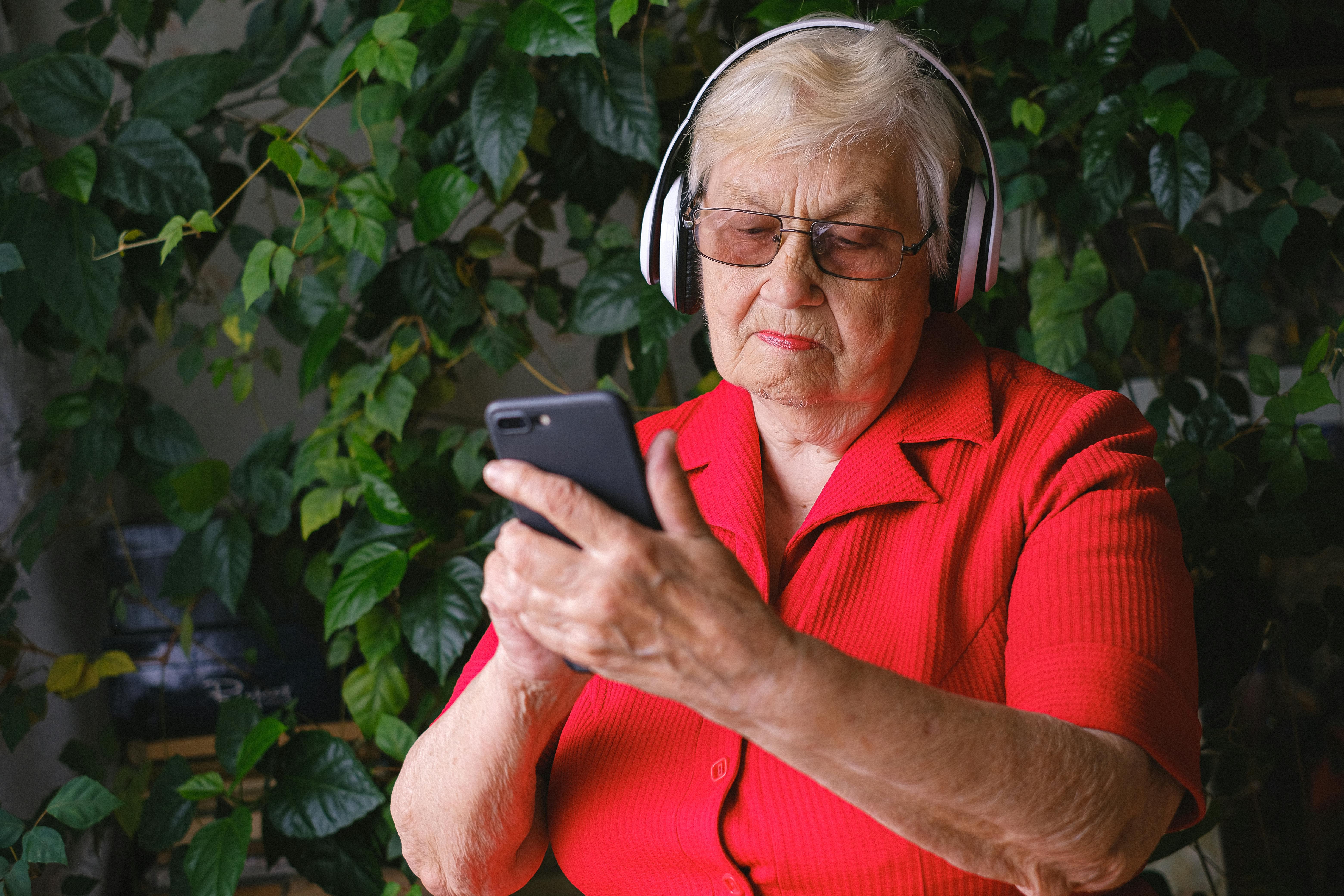 A tech-savvy older woman operating a mobile phone | Source: Pexels