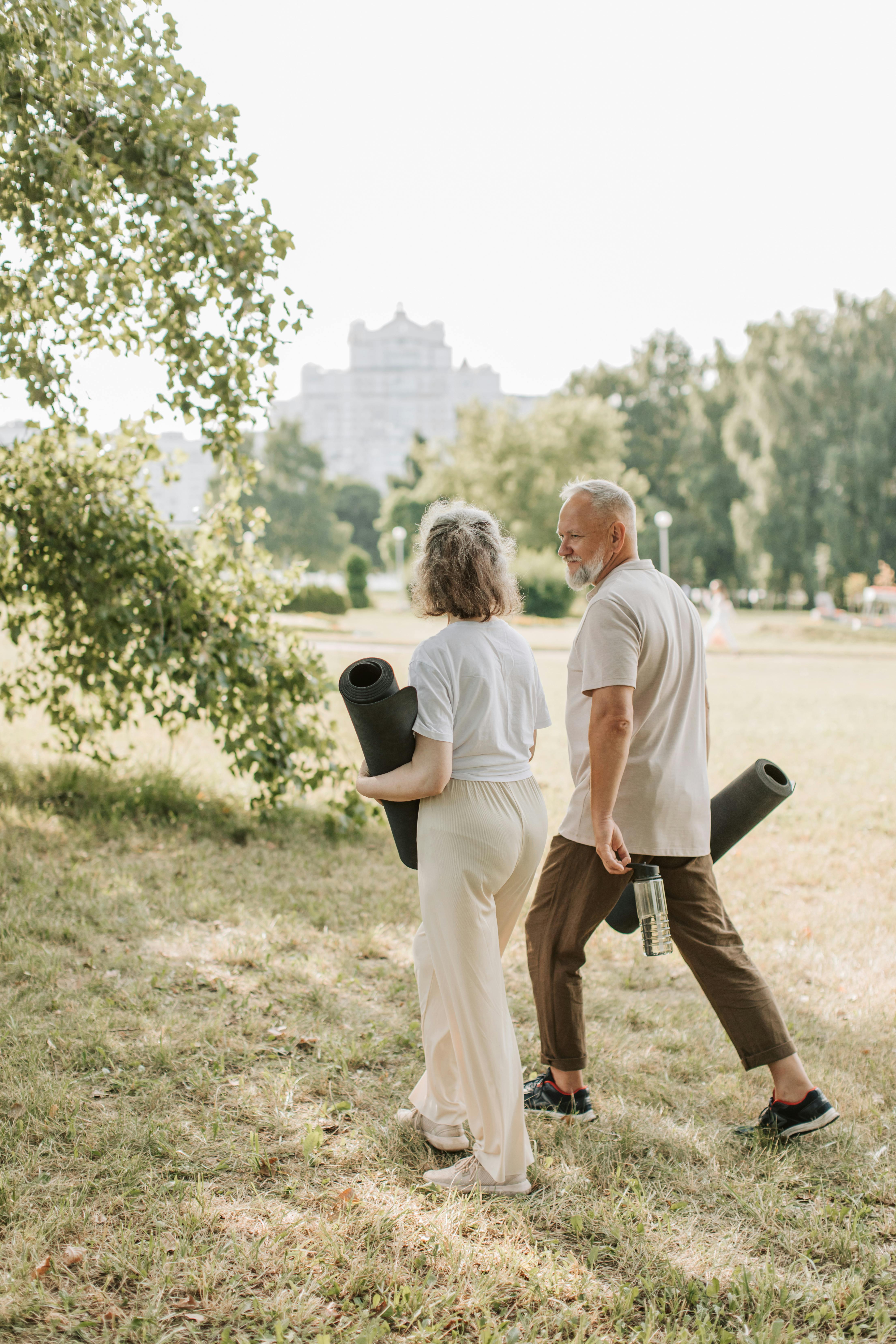 Senior couple holding yoga mats | Source: Pexels