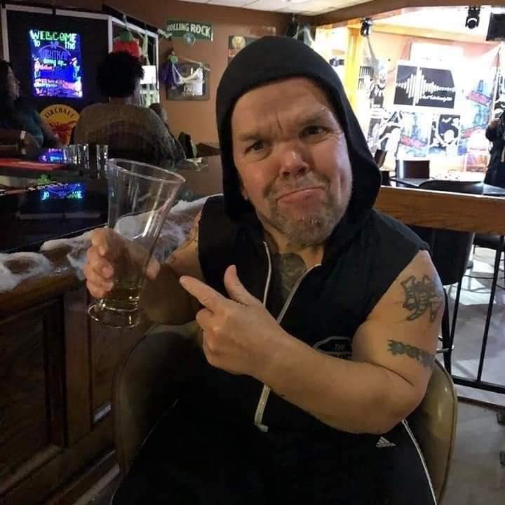 Former wrestler Stevie Lee Richardson, known as Puppet The Psycho Dwarf in the ring, at a bar posing with an empty glass | Photo: Jacob Colyer via GoFundMe