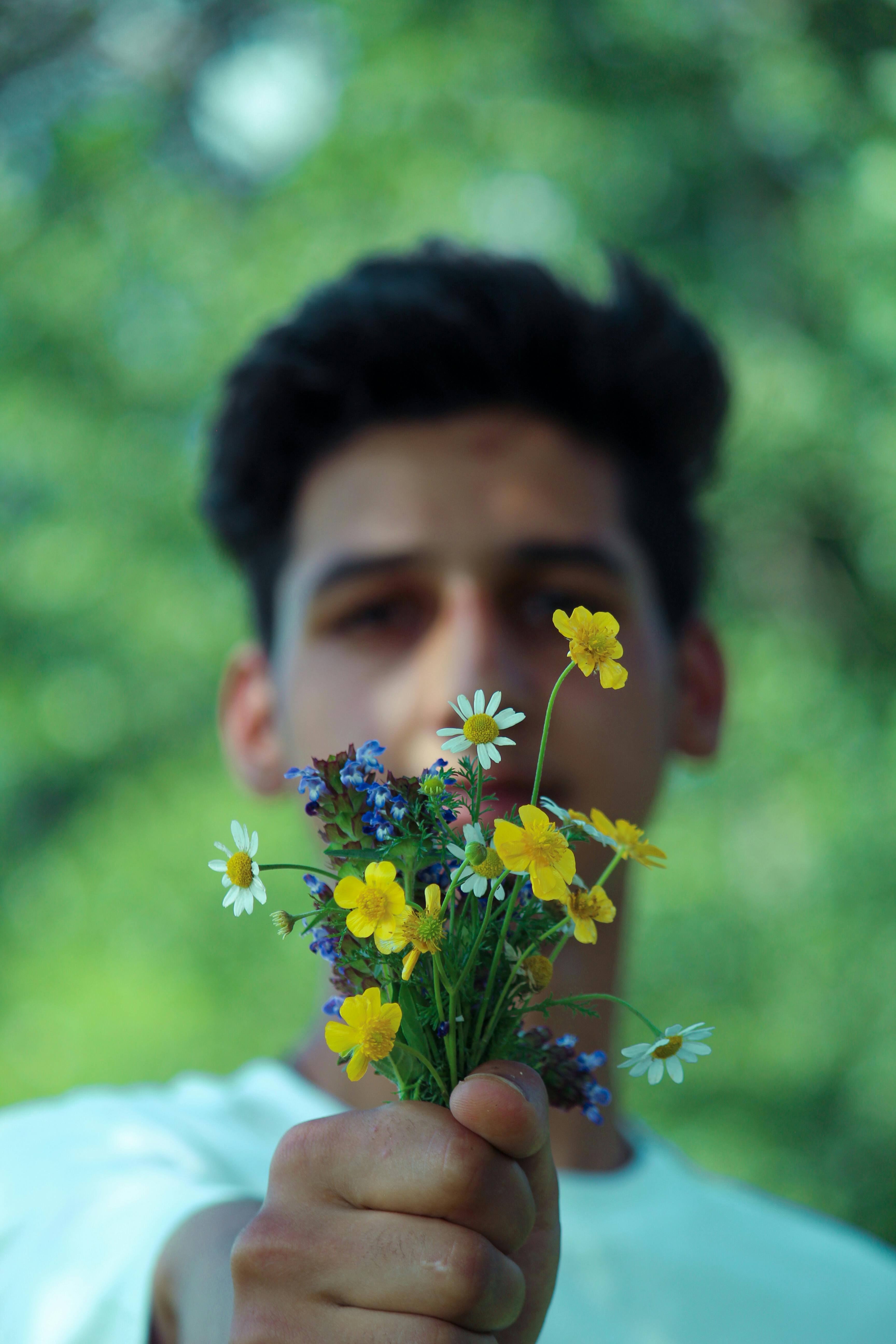 A man handing over flowers | Source: Pexels