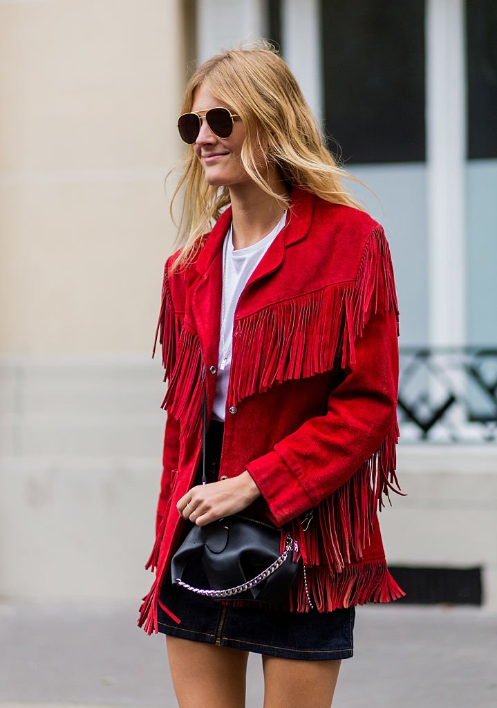 Une femme portant une veste rouge avec des franges. | Photo : Getty Images