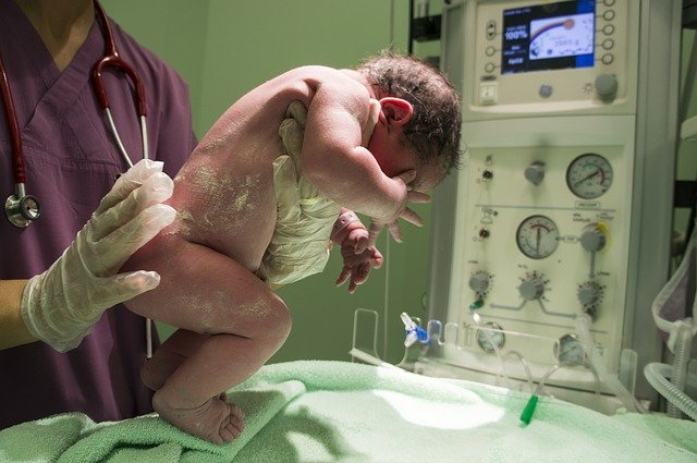 A newborn is cleaned by a nurse in the delivery room. | Photo: Pixabay.