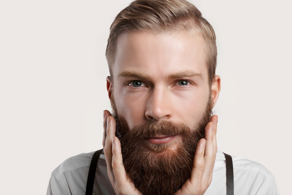 Un homme qui touche sa barbe. | Photo : Shutterstock 