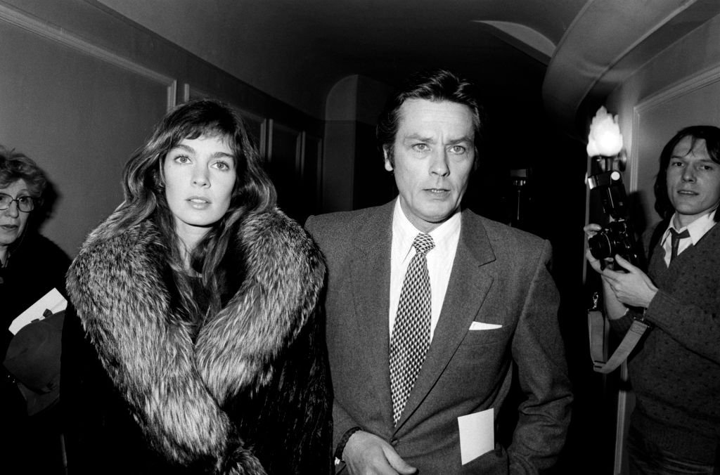 Alain Delon et Anne Parillaud à la première du spectacle de Thierry Le Luron à Paris en 1982, France.| Photo : Getty Images
