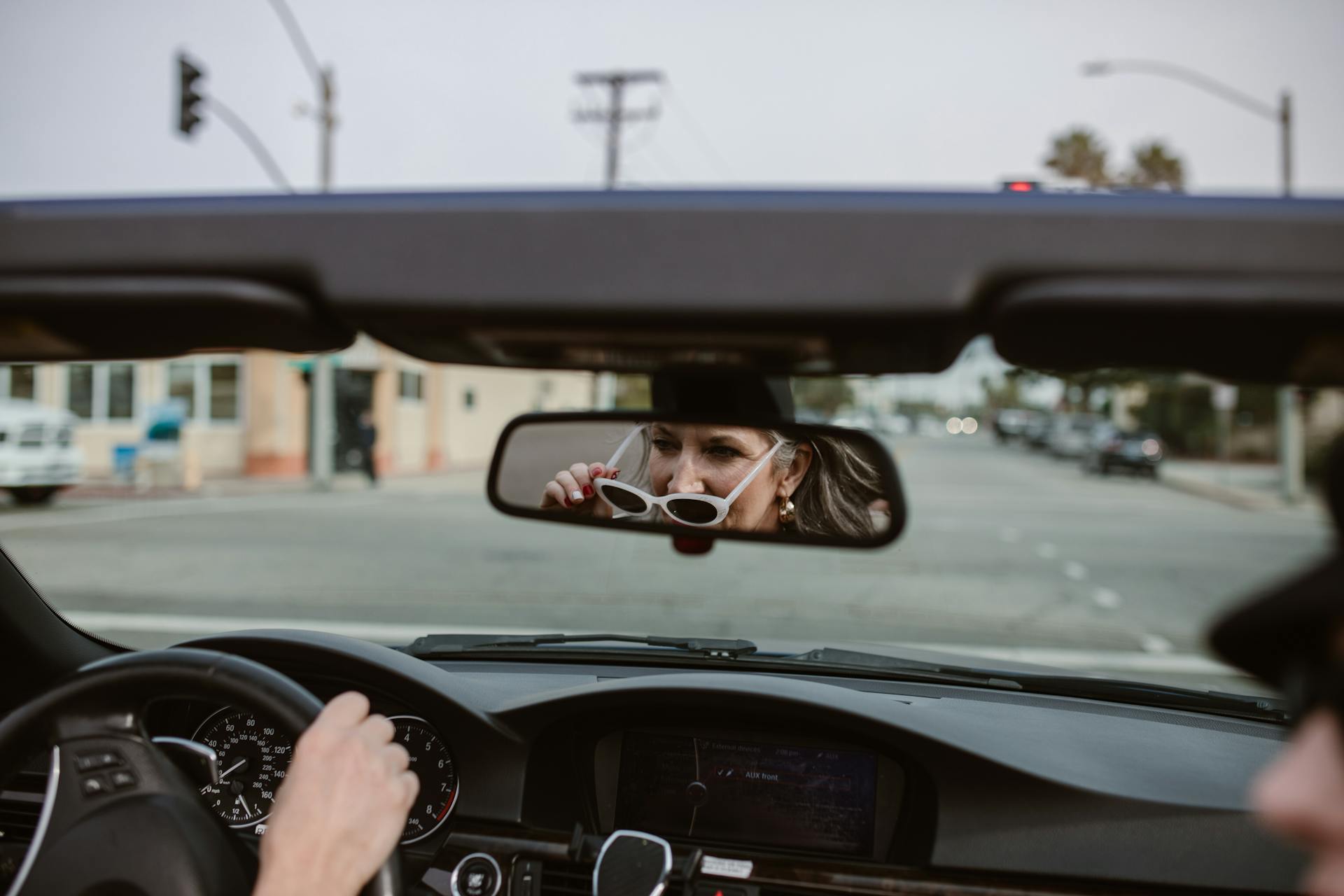 A reflection of a middle-aged woman in the rearview mirror driving a car | Source: Pexels