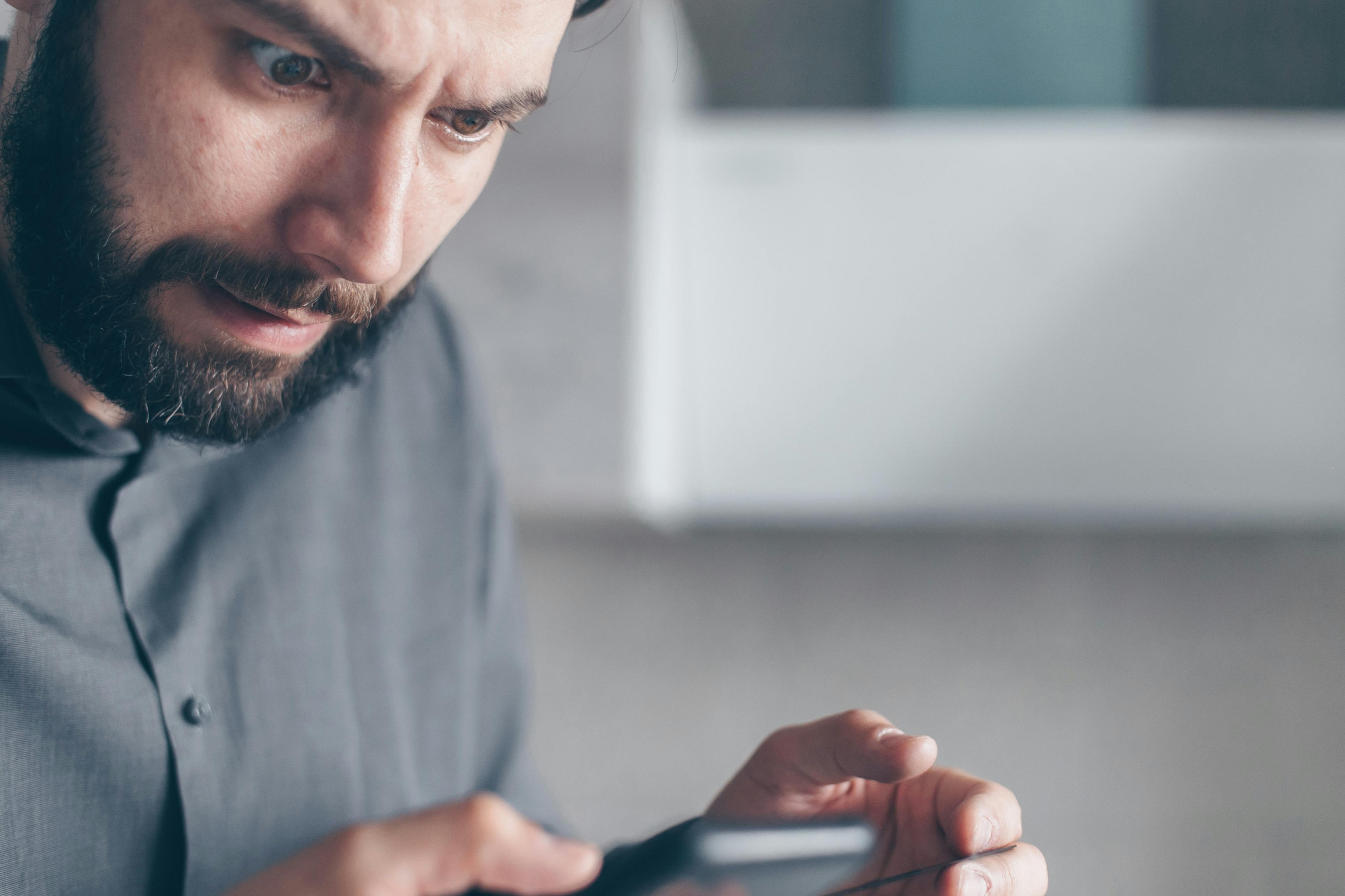 A shocked man looking at his phone | Source: Pexels