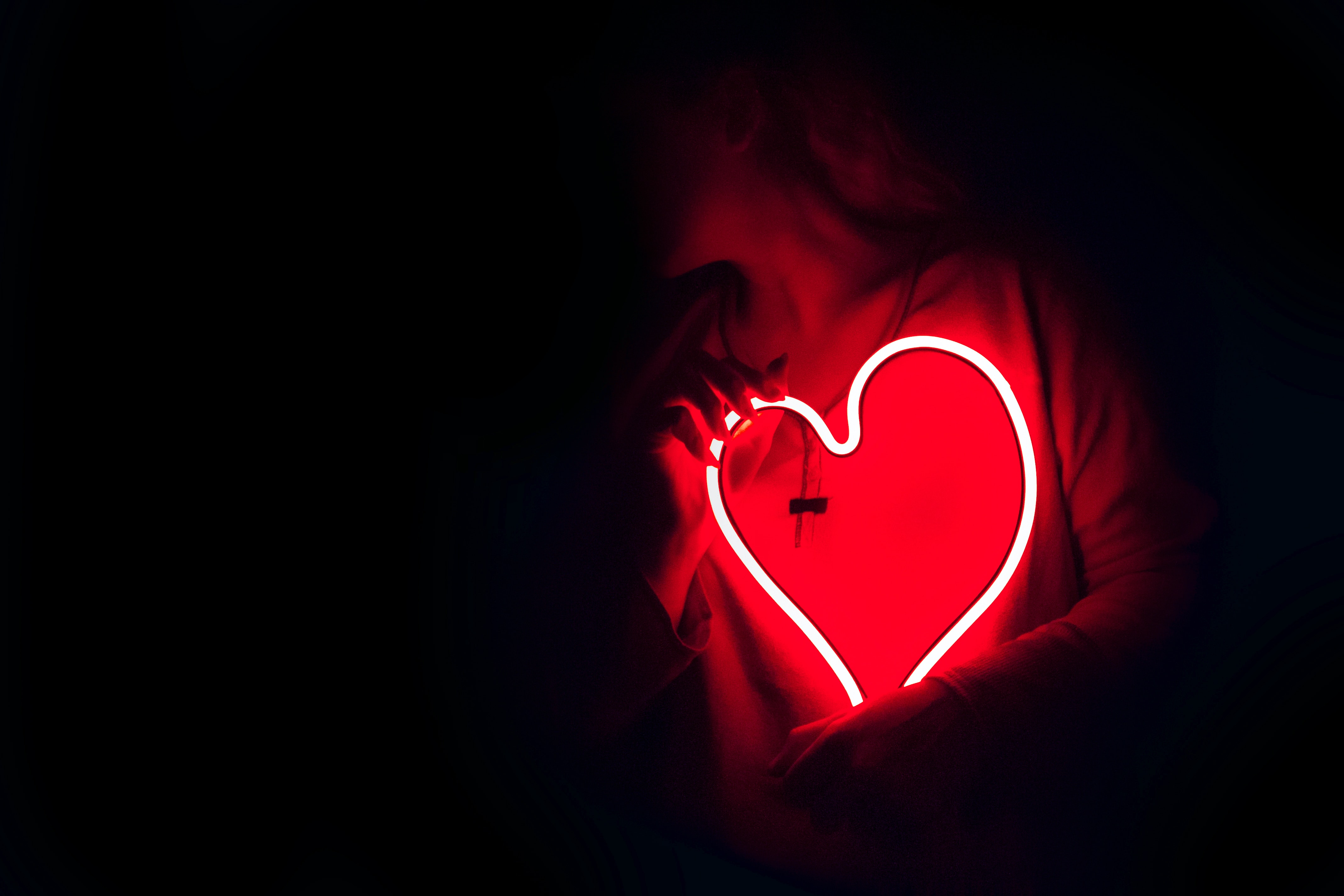 An image of an individual holding a glowing heart to their chest. | Source: Unsplash