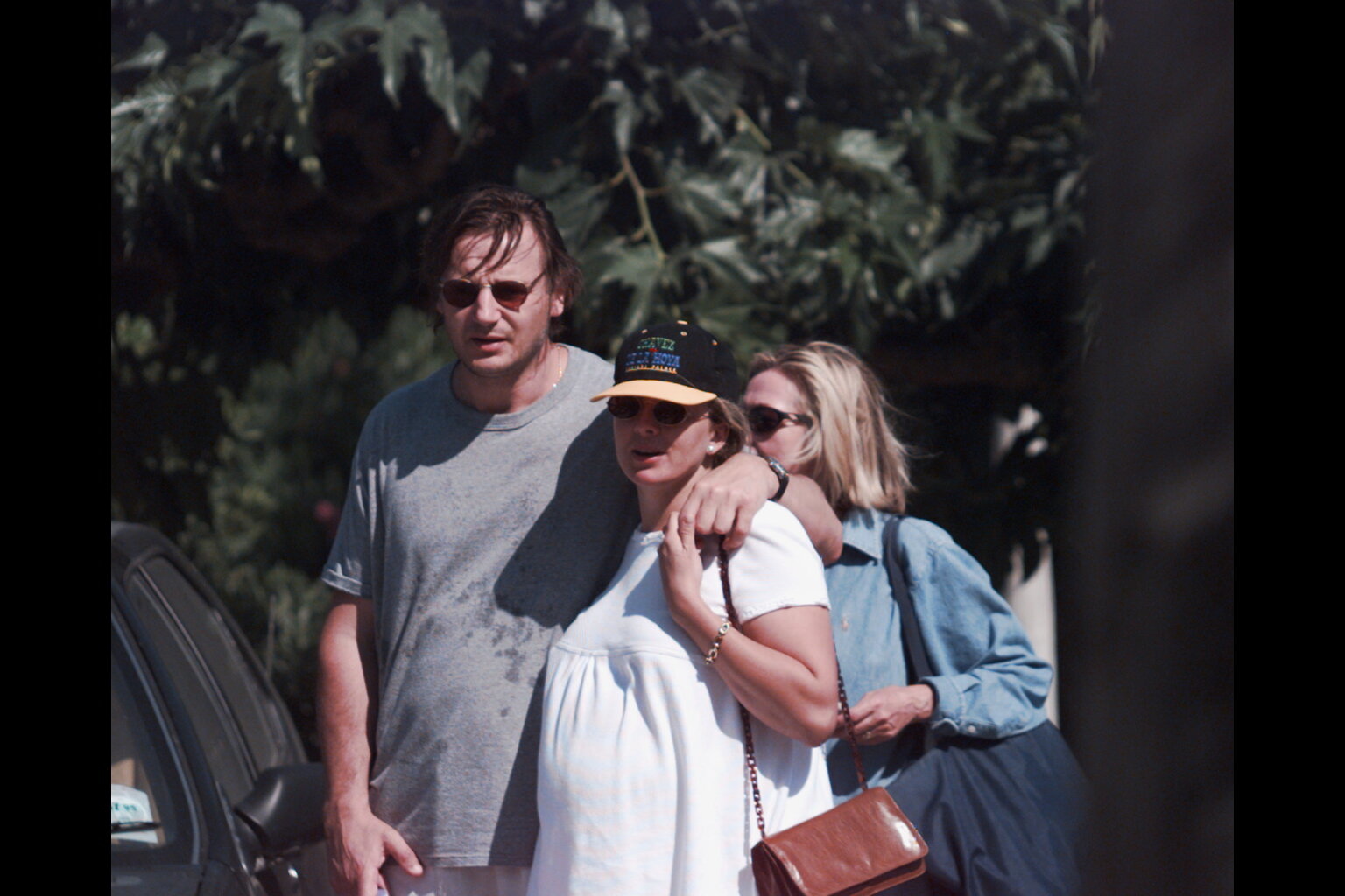 Liam Neeson walks with his arm around Natasha Richardson during a casual outing in St. Tropez on July 4, 1996. The couple appears relaxed while enjoying their time outdoors in the summer setting.